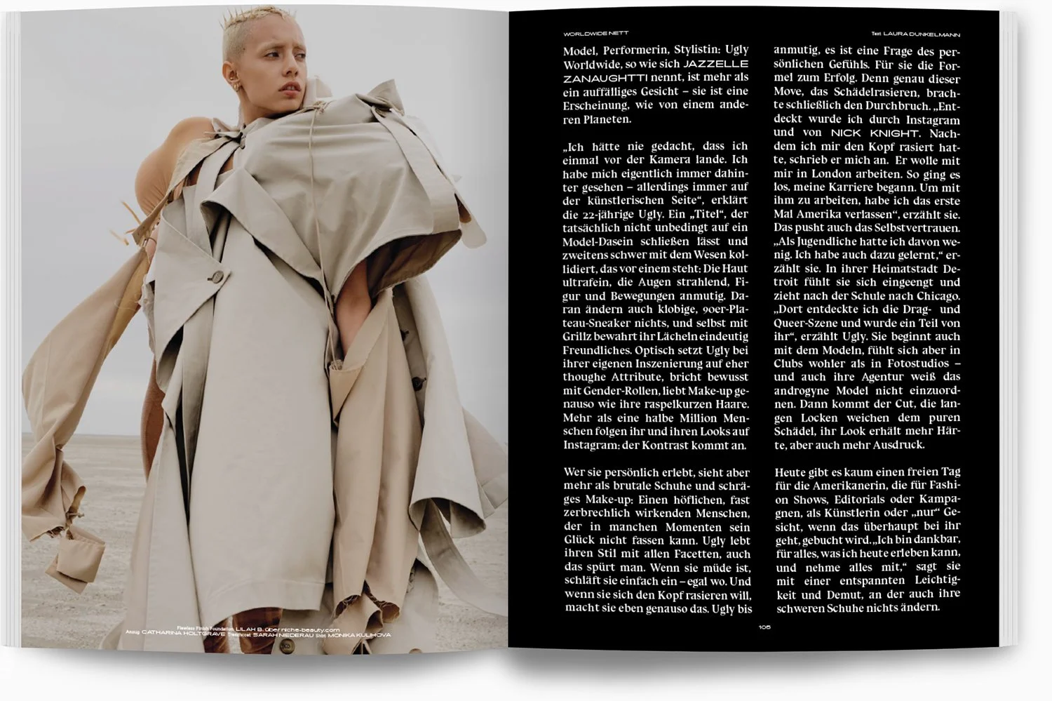 Ein Model mit kurzen, hellen Haaren trägt einen beige Trenchcoat auf einer Wüstenlandschaft. Der Himmel ist grau.