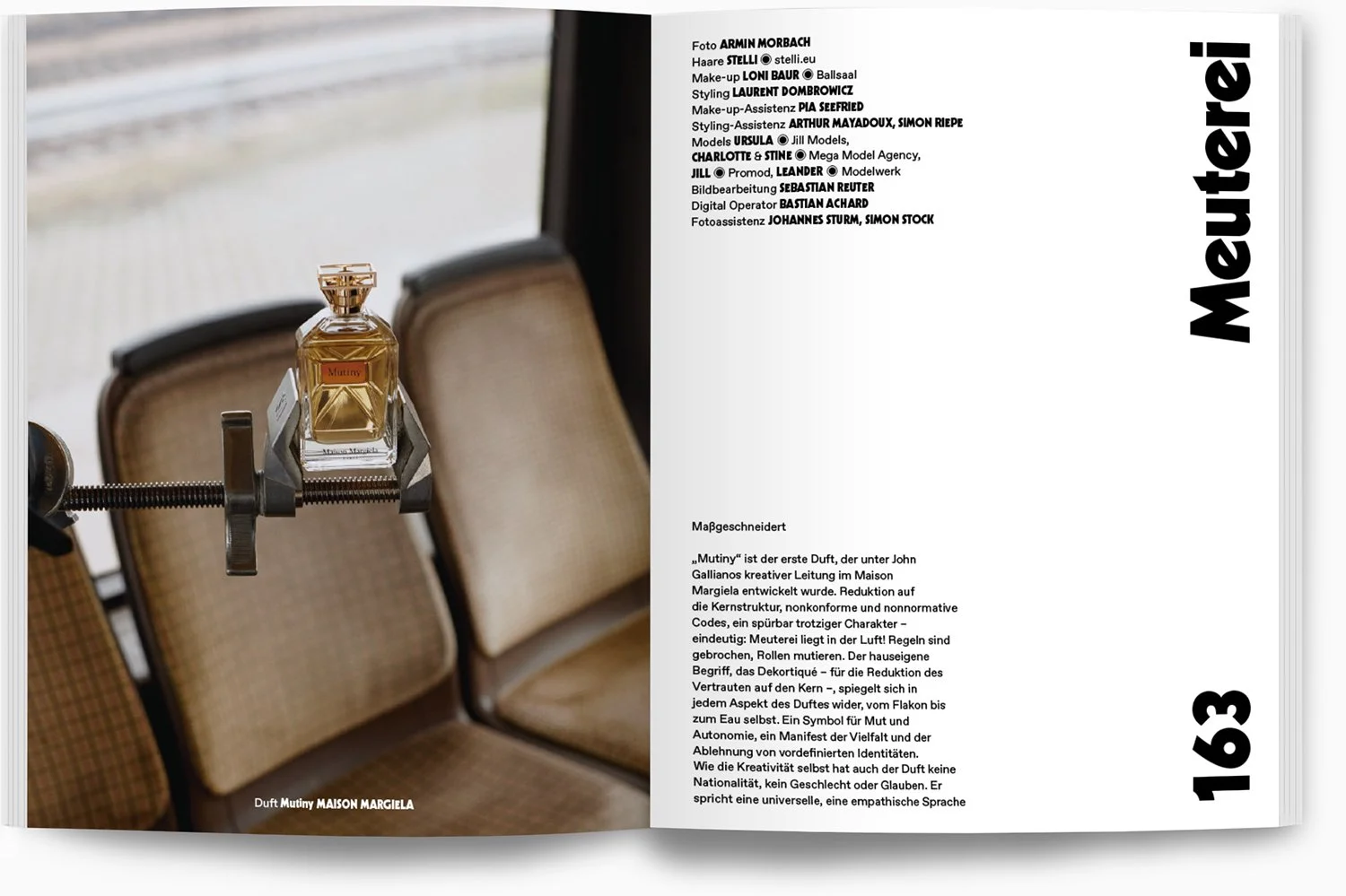 Ein Parfüm-Flakon auf einer kleinen Plattform, eingeklemmt in einer Klemme, mit einem Hintergrund aus zwei angrenzenden Stühlen.