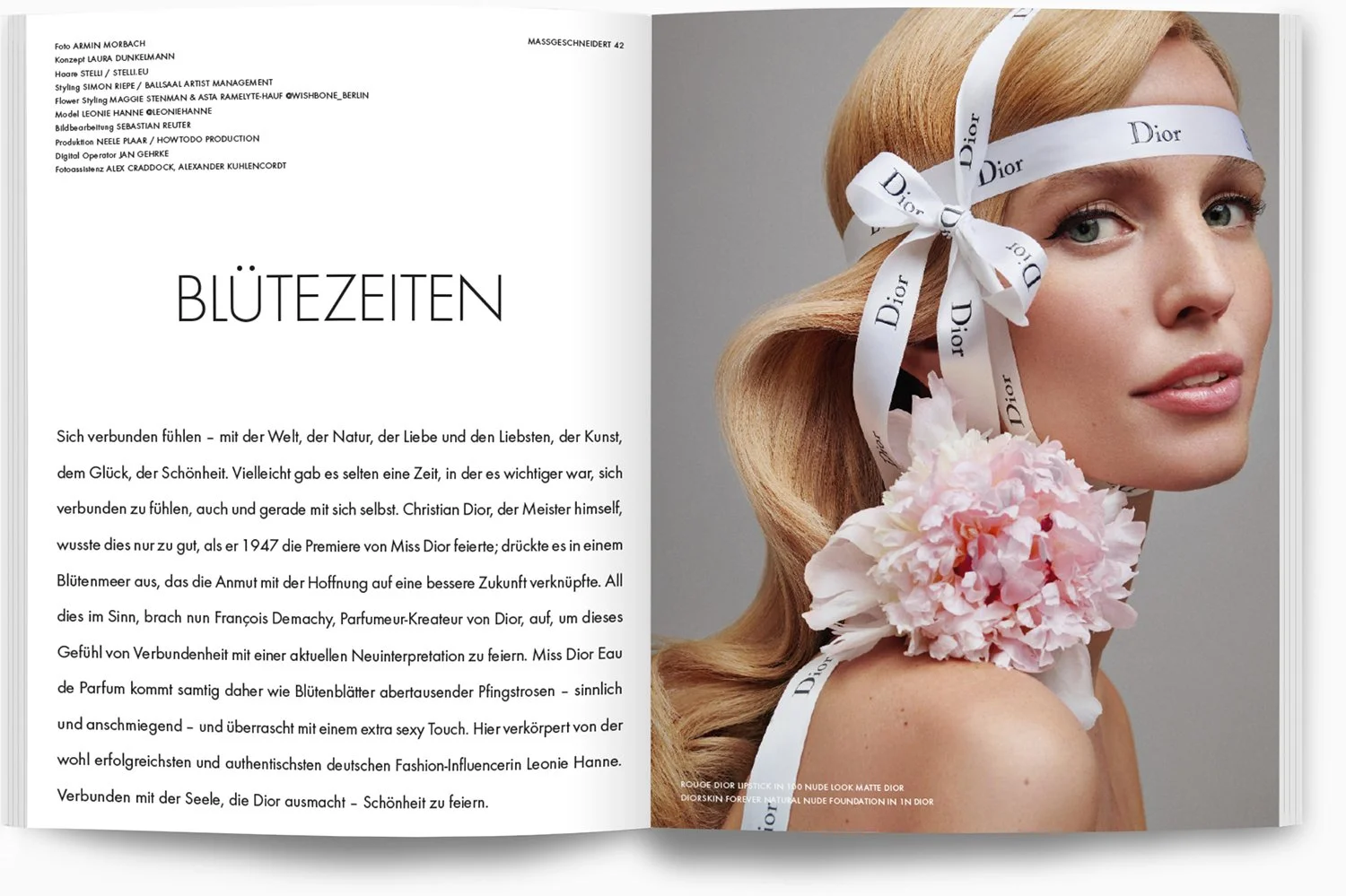 Eine Frau mit blonden, gewellten Haaren trägt einen weißen Dior-Schleife-Haarband und einen großen, rosa Pfingstrosenblumenkranz um den Hals. Das Bild ist eine Modeaufnahme mit einem neutralen grauen Hintergrund.