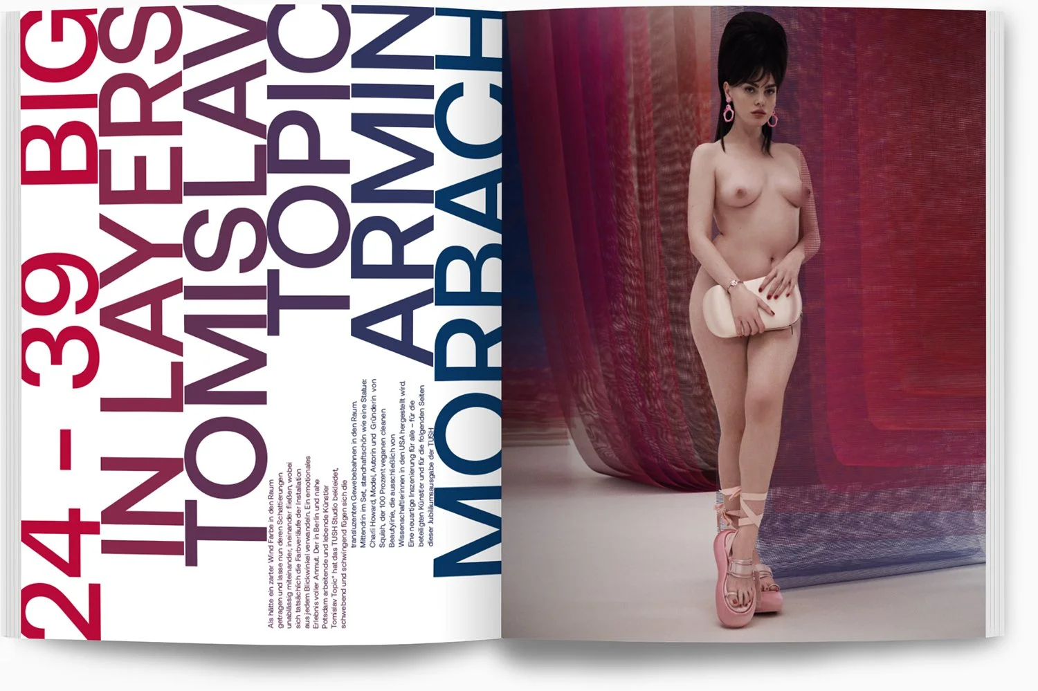 Eine nackte Frau mit schwarzen Haaren, pinken Ohrringen und rosa Schuhen, die einen weißen Beutel hält, steht vor einem roten Vorhang.