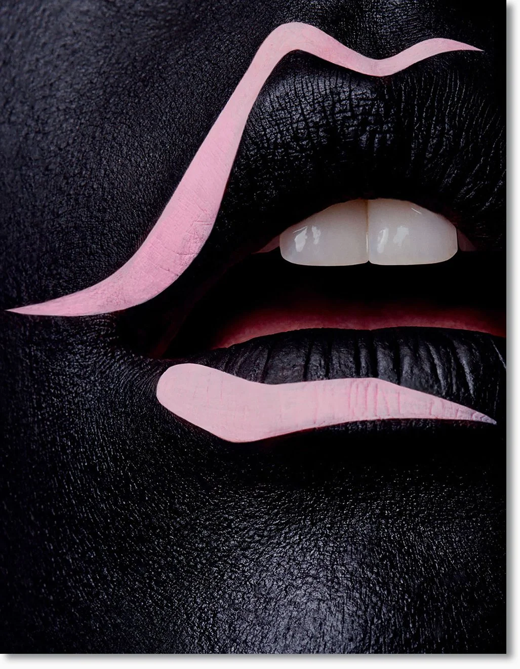 Nahaufnahme eines Mundes mit schwarzen Lippen, pinken Make-up-Linien auf Lippen und Wangen, weiße Zähne, und die Zunge ist leicht sichtbar.