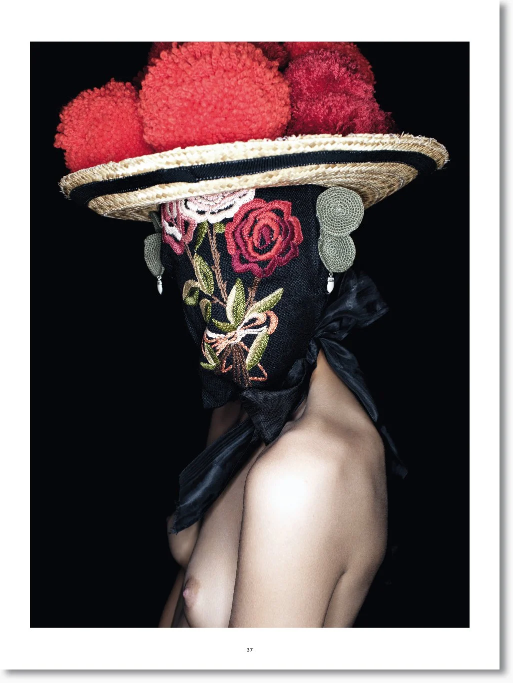 Künstlerische Fotografie einer nackten Person mit einem Haus aus Blumen und Stoff bedeckt, um das Gesicht zu verdecken, mit einem schwarzen schwarzen Hintergrund.