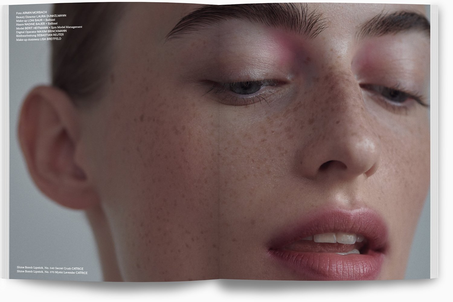 Nahaufnahme eines Gesichts mit Sommersprossen, geschlossenen Augen und leicht geöffnetem Mund.