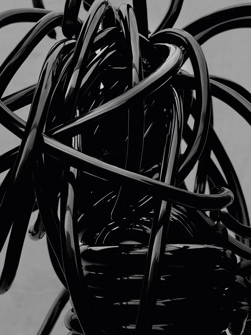 A tangled mess of black plastic or metal wires, forming a chaotic, abstract pattern.