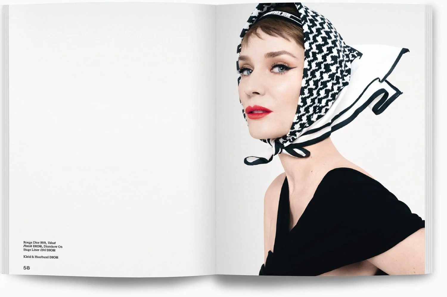 Frau mit rotem Lippenstift, auffälligem Make-up und schwarz-weißem Kopftuch, die schwarze Kleidung trägt, vor hellem Hintergrund.