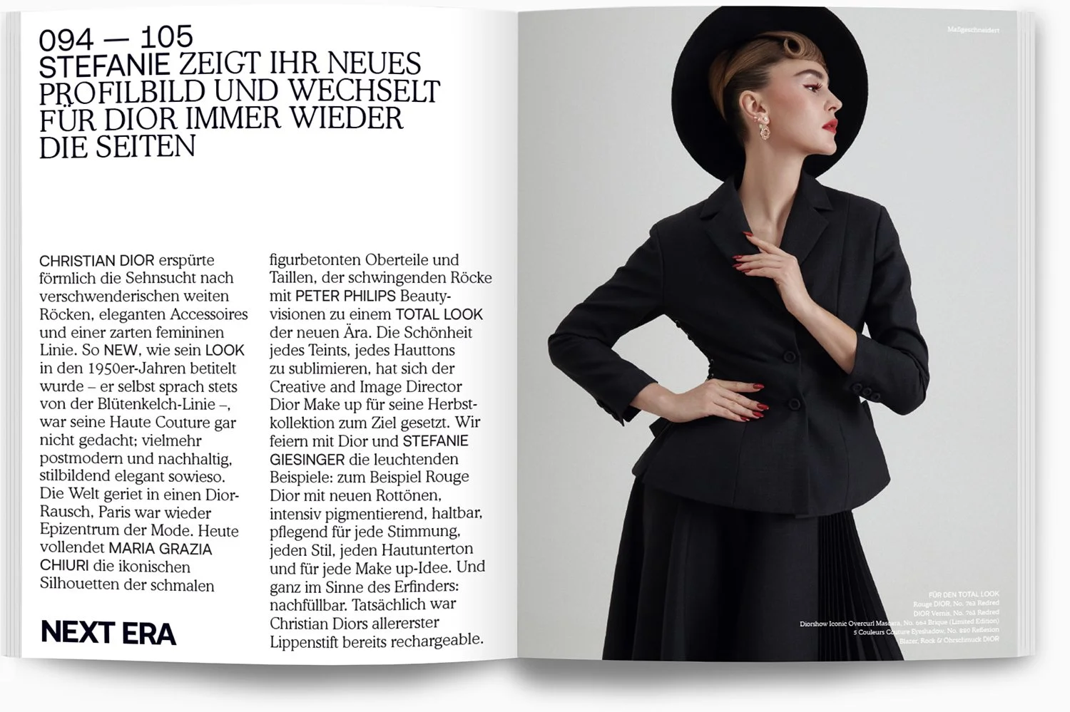 Eine Frau im schwarzen Blazer und weitem schwarzen Rock trägt einen schwarzen Hut und rote Make-up, sie steht seitlich und berührt ihre Brust mit ihrer rechten Hand.