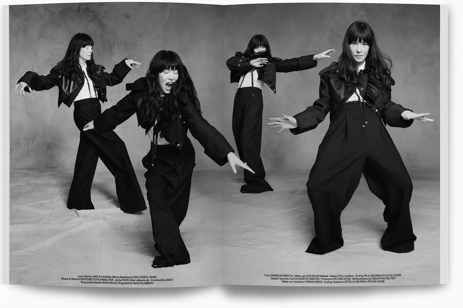 Vier Frauen in schwarzen Modeoutfits posieren in einem Fotostudio. Die Szene ist in Schwarz-Weiß.