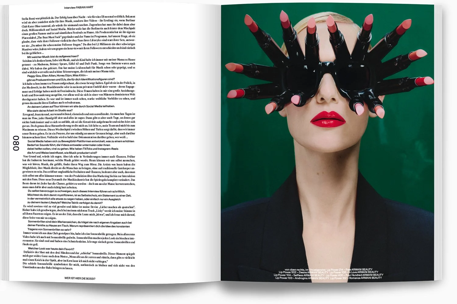 Frau mit roten Lippen und dunklem Oberteil, trägt schwarzen Handschuh mit mehreren Fingern, der wie ein Handkran vor ihrem Gesicht positioniert ist, vor grünem Hintergrund.