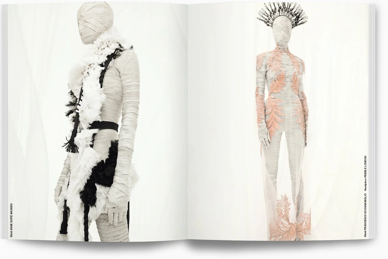 Zwei mannequinen in avantgardistischer Kleidung aus einem Modekatalog, eine in schwarz-weißer Felloptik mit großen Texturen, die andere in zartrosa mit floralen Stickereien, beide tragen einzigartige Kopfbedeckungen.