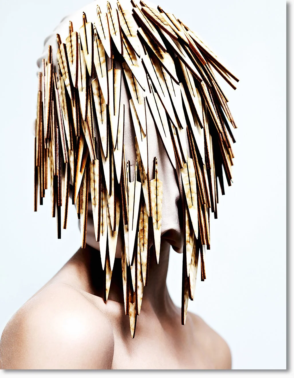 Kunstinstallation eines menschlichen Kopfes mit Fell aus vielen spitzen Holzstäbchen.