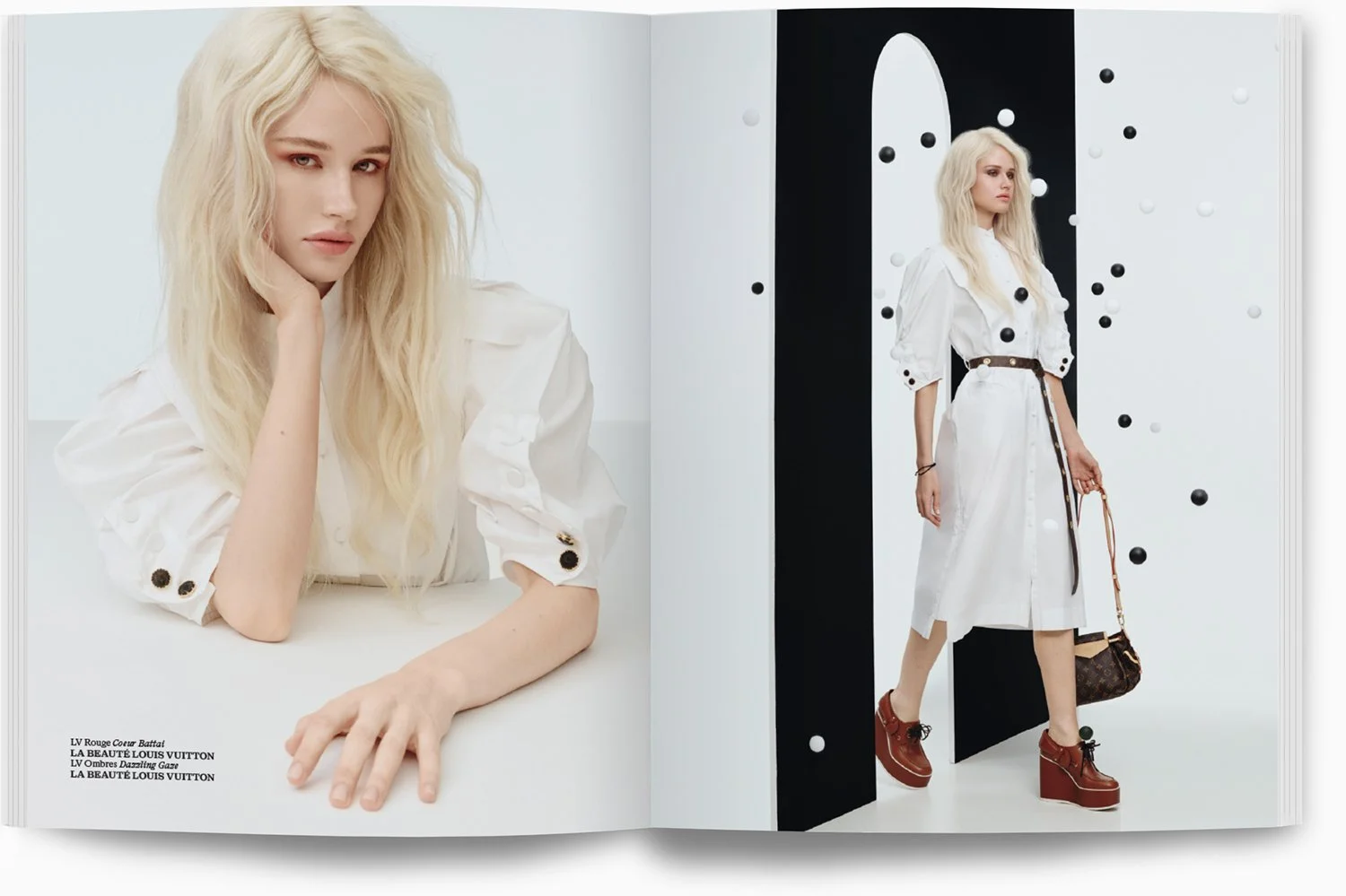 Ein Modefotobild, zeigt eine blonde Frau tragend ein weißes Kleid mit schwarzen und weißen Knöpfen, die mit einer schwarzen und goldenen Gürtelschnalle und braunen Plattformschuhen. Das Bild ist in einem modernen, minimalistischen Setting mit schwarz