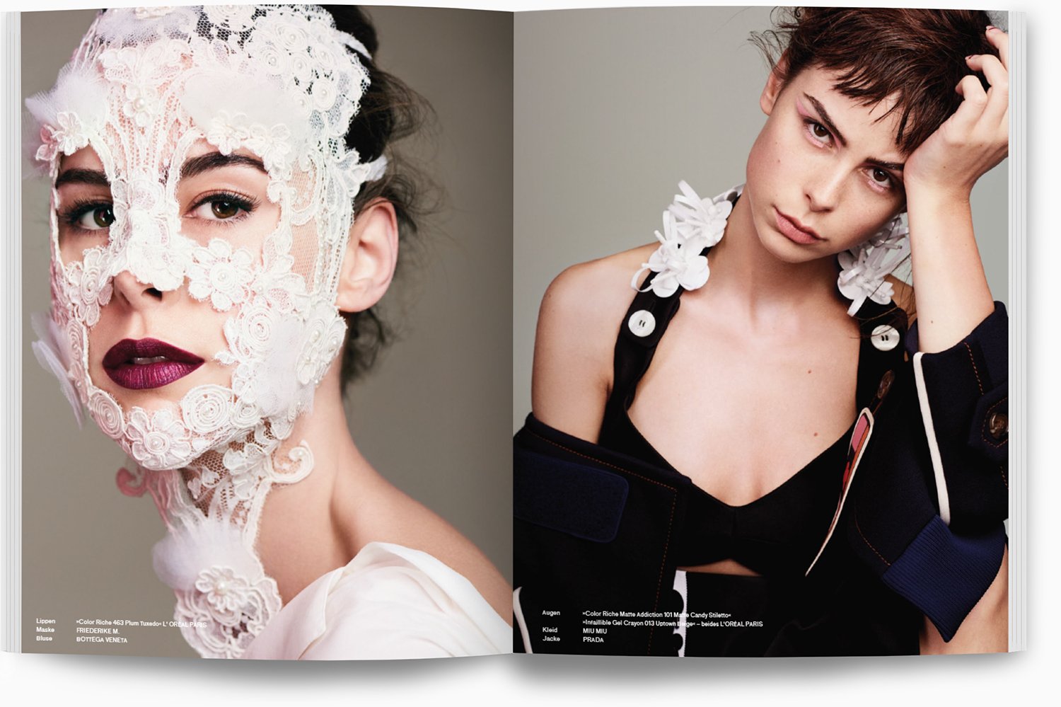 Zwei Frauen in modischer Kleidung und Makeup, eine trägt ein filigranes weißes Spitzenmaske, die andere hat kurze braune Haare und trägt eine schwarze Kleidung mit weißen Blüten am Ärmel.