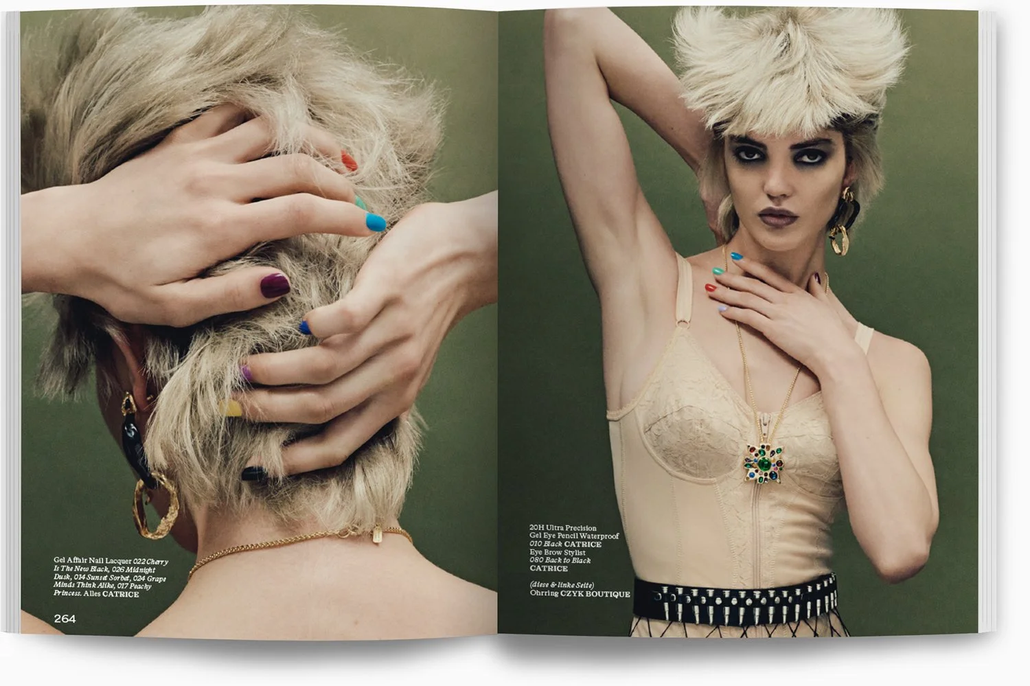 Modell mit blonder, stufiger Frisur posiert gegen grünen Hintergrund, trägt cremefarbenes Top mit Spitze, große Ohrringe, bunte Nagellacke, Schmuck und schwarzes Gitterrock.