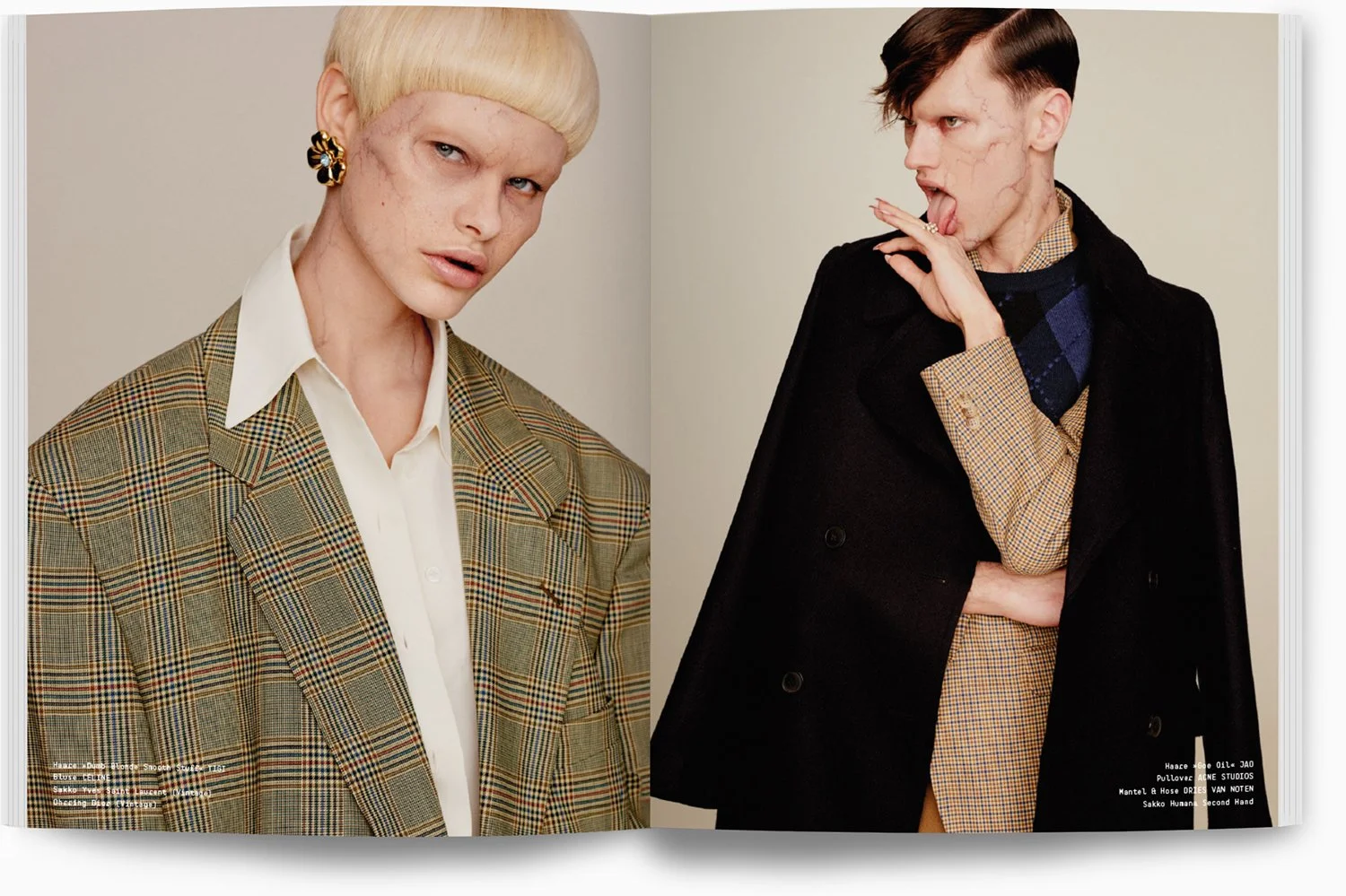 Zwei Models in Vintage-Kleidung, eine blonde Frau auf der linken Seite trägt ein kariertes Blazer und einen weißen Hemd, eine braune haare Model mit dunklen Haaren und als Mann gekleidet trägt einen schwarzen Mantel und einen braunen Anzug. Beide sch