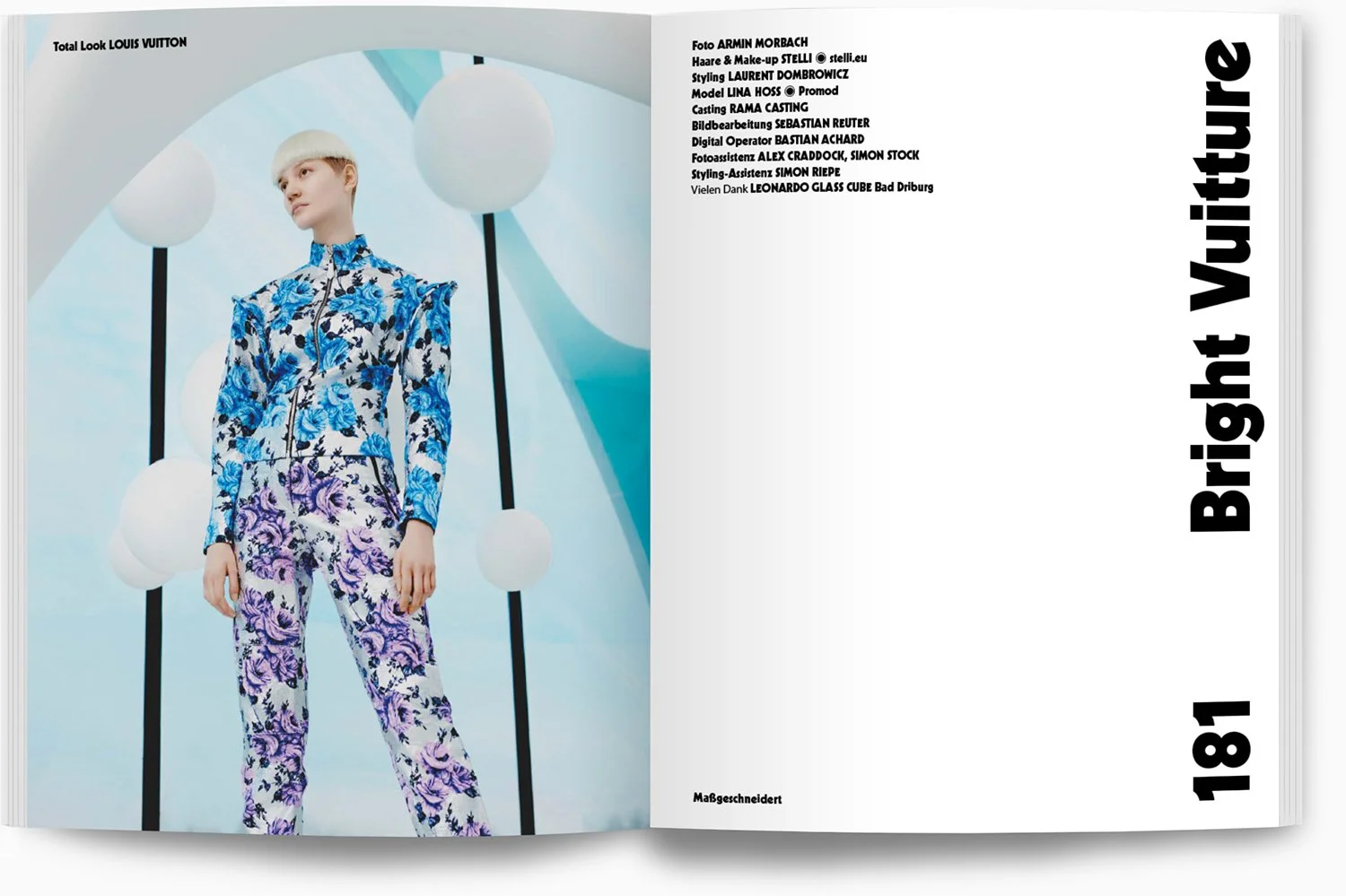 Modisches Model in einem Blümchen-Outfit vor einem modernen Hintergrund mit weißen runden Lampen.