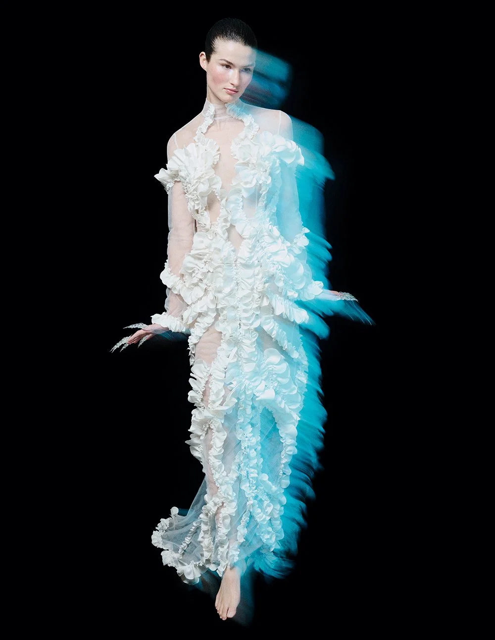 Frau in einem weißen, voluminösen Kleid mit Rüschen auf schwarzem Hintergrund, mit Bewegungsunschärfeeffekt