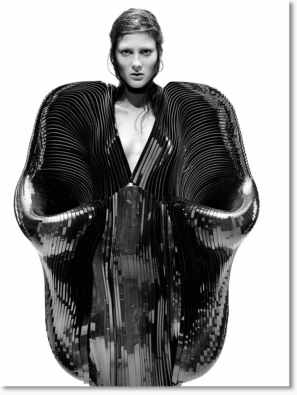 Schwarze und weiße künstlerische Fotografie einer Frau, deren Oberkörper und Schultern durch ein mechanisch wirkendes, geometrisches Kunstwerk ersetzt sind.