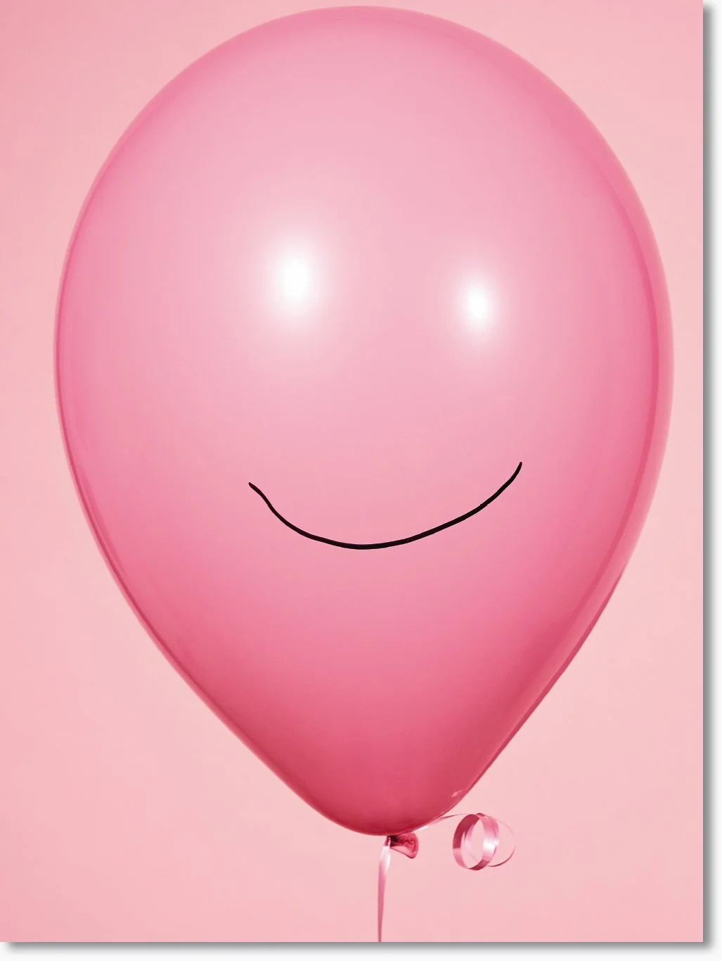 Ein rosa Ballon mit einem lachenden Mund, auf hellem rosa Hintergrund.