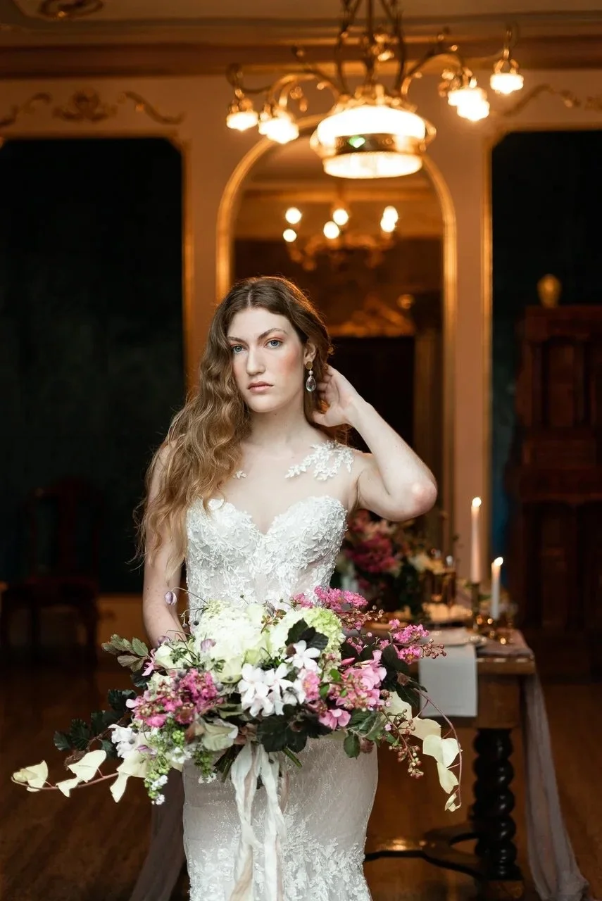 Donna in abito da sposa con bouquet di fiori in un ambiente elegante e illuminato
