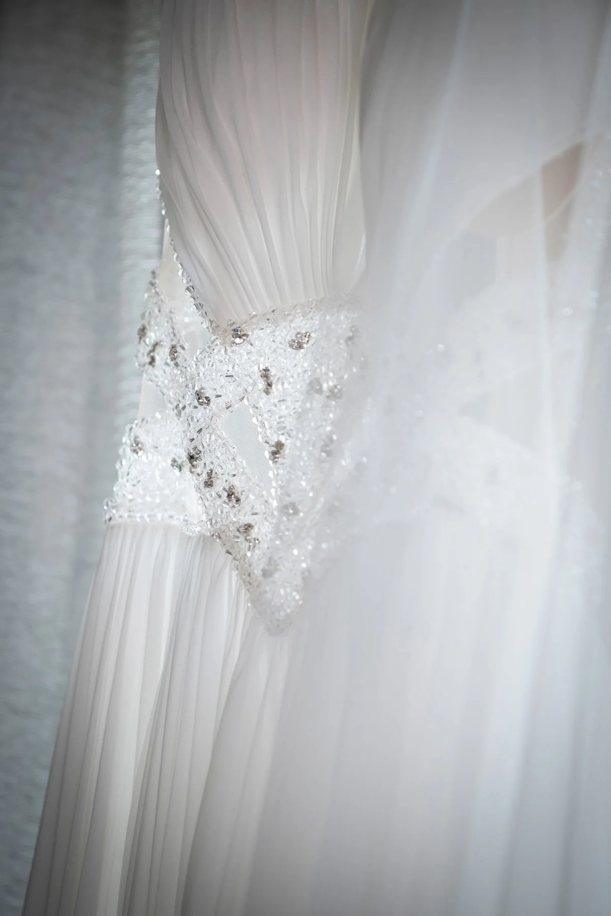 Linea di filato di tessuto bianco con dettagli di cristalli e sfondo luminoso. Como Wedding Planner