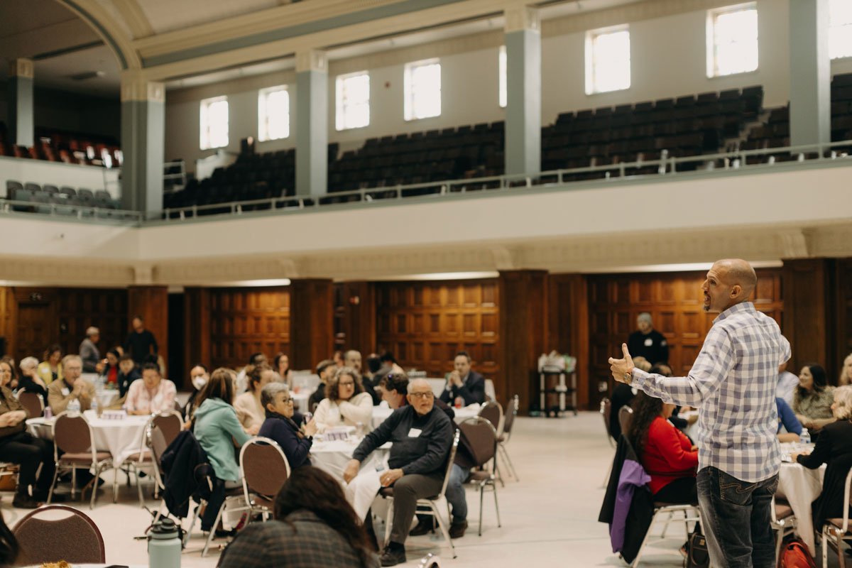 Tamien speaking to a room full of people
