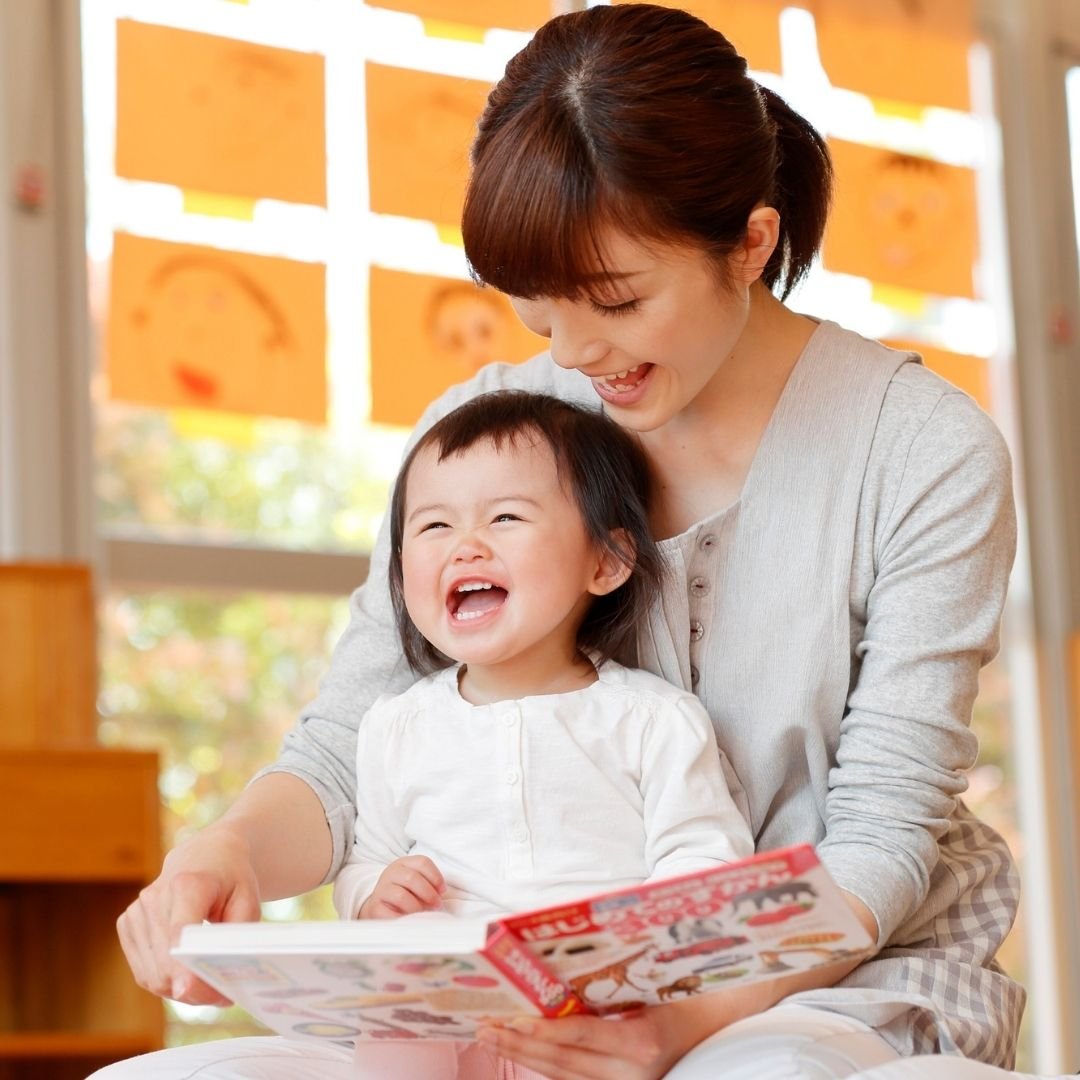 An infant and caregiver reading a book.