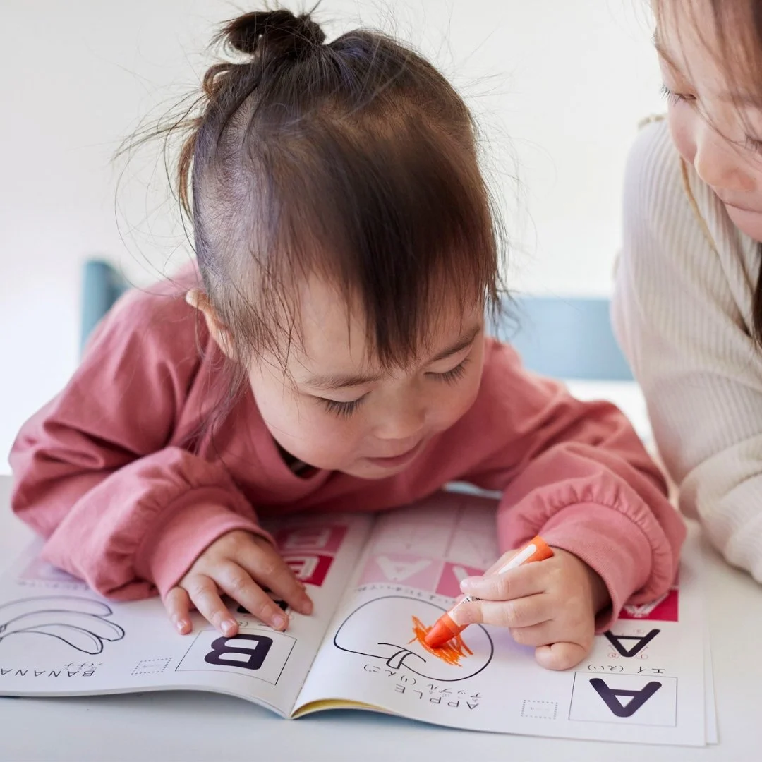 Toddler coloring a fruit in a book