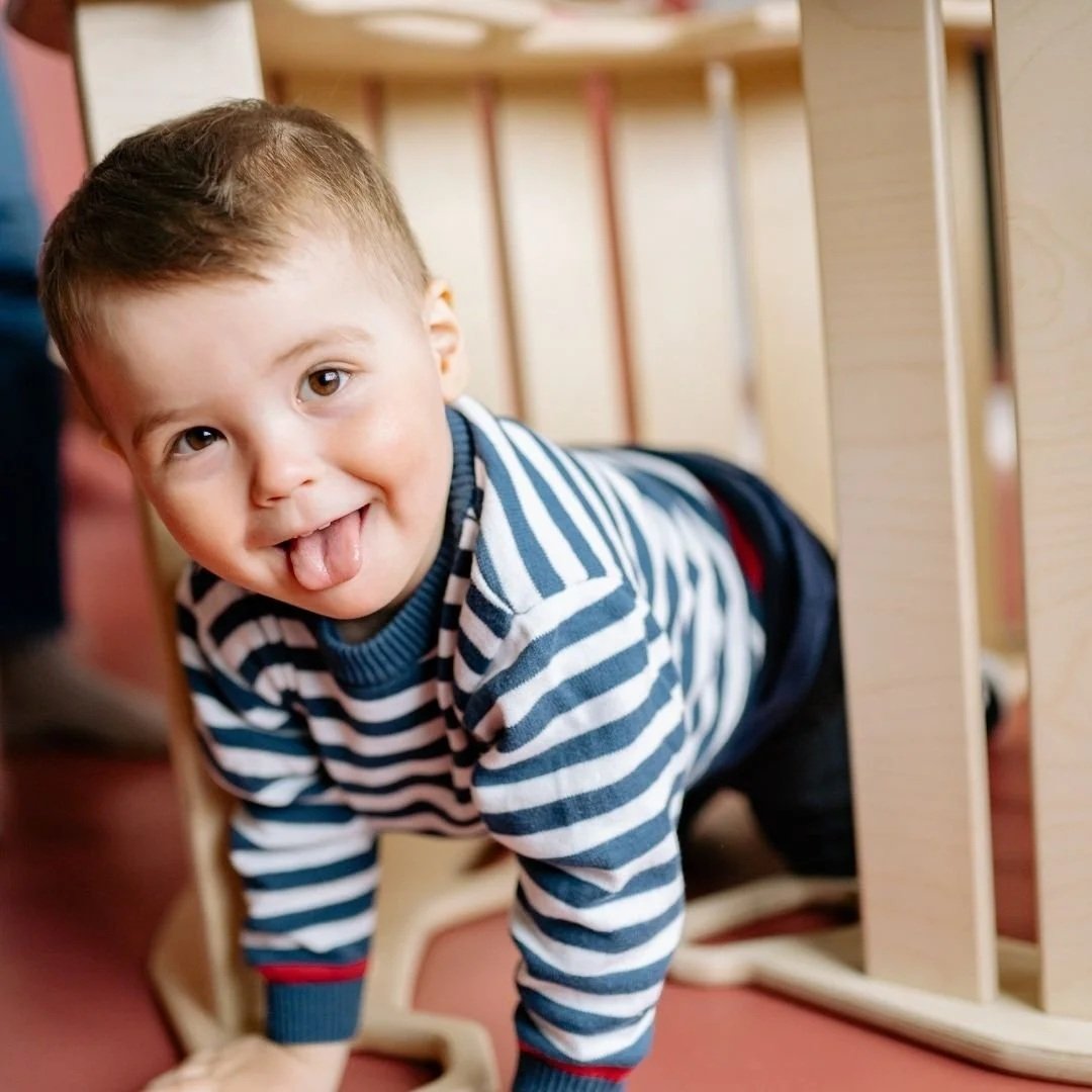 An infant crawling on the floor.