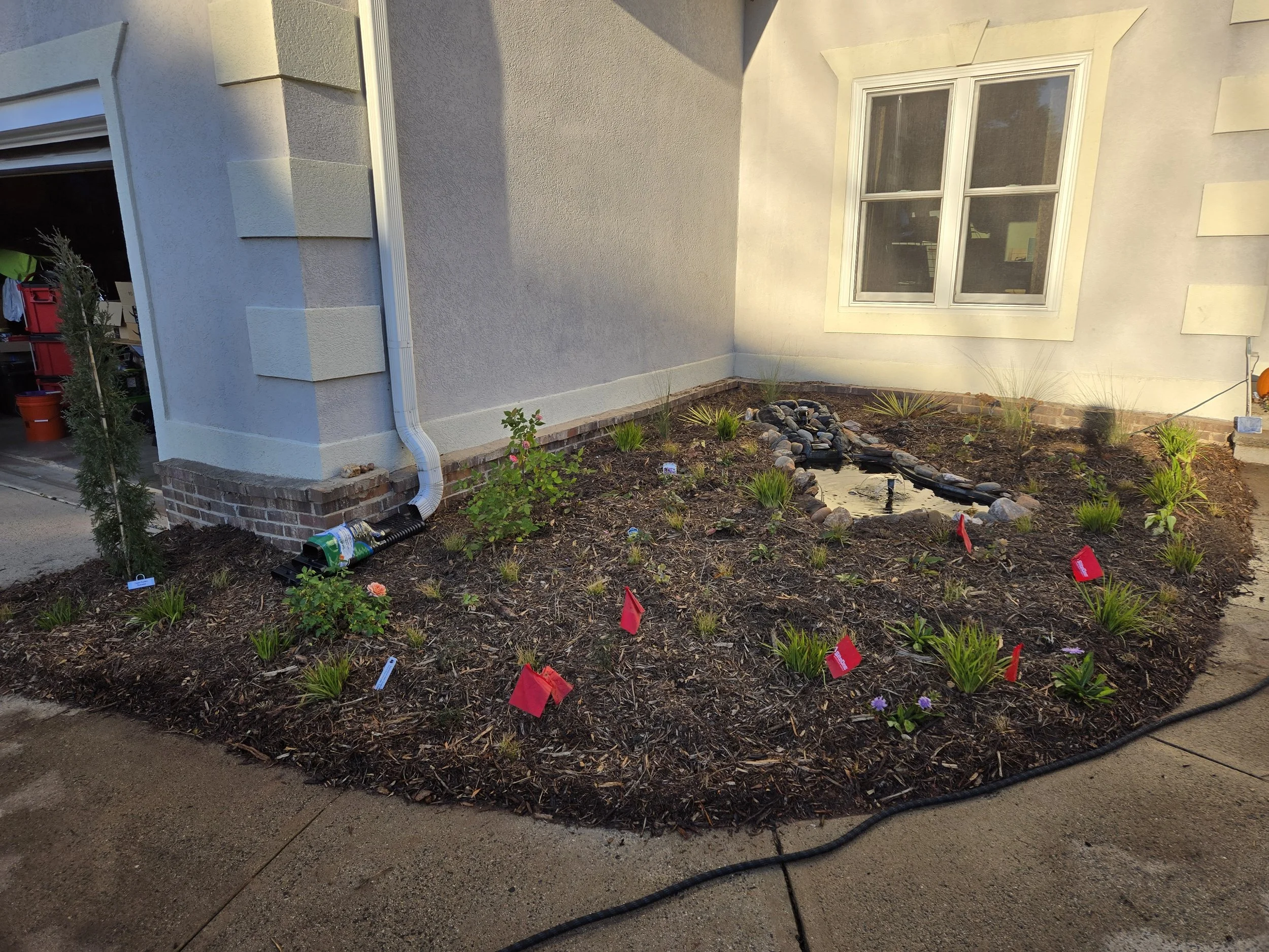 After - front left foundation beds with yucca and muhly in back with mix of low flowers/grasses in front