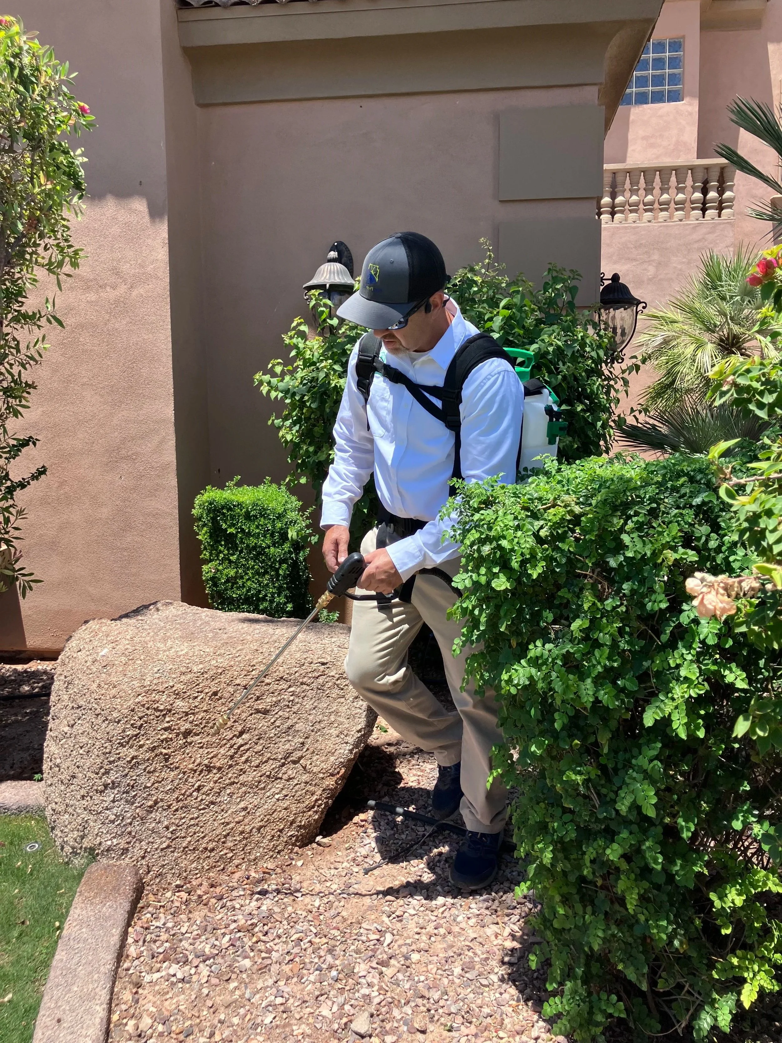 Matt, owner of Pest Free AZ, spraying the exterior perimeter of an East Valley home during a customized pest control treatment.