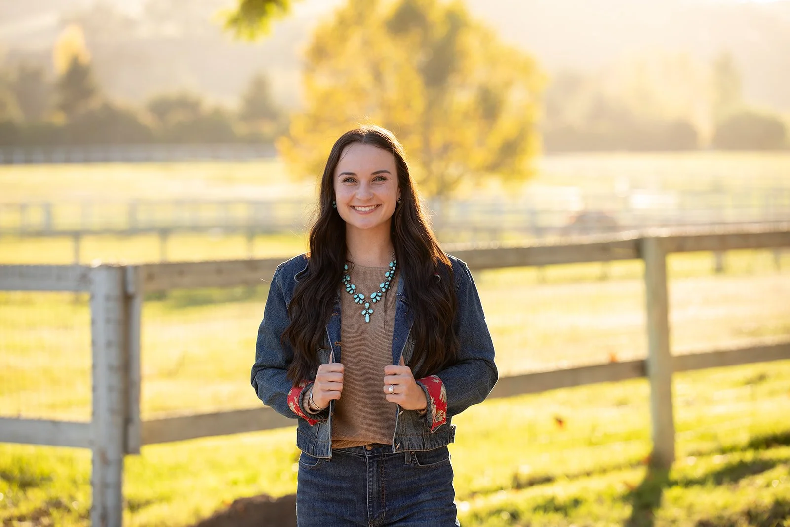 Woman in a denim jacket smiling in a pasture in Santa Ynez Valley.