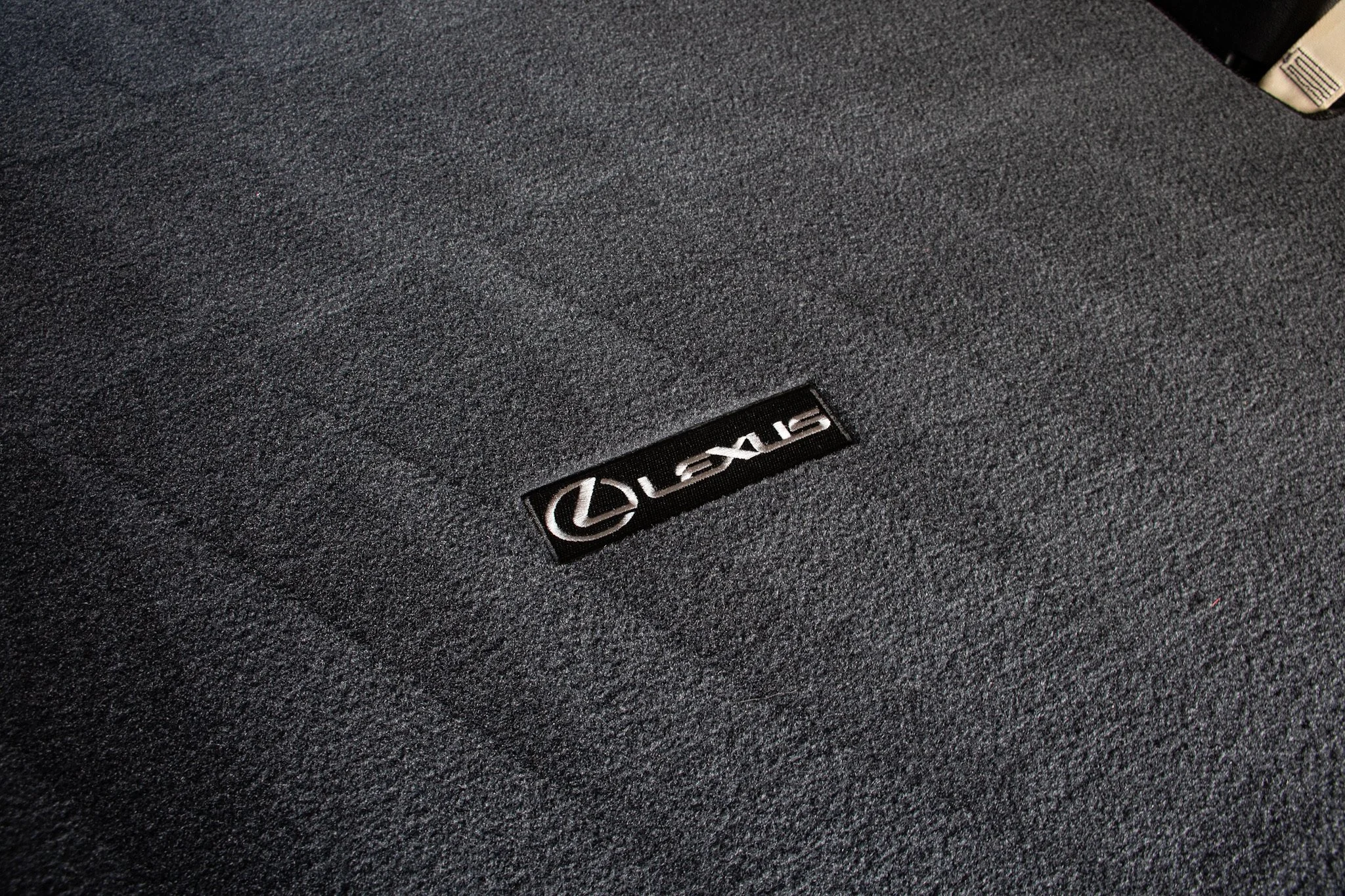 Close-up of a black speaker with the Lexus logo.
