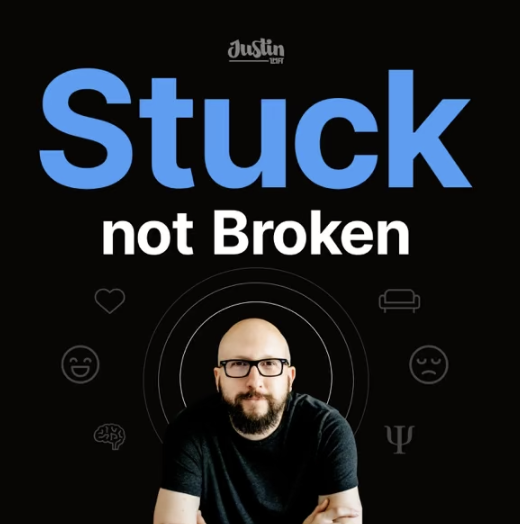A black background with the phrase "Stuck not Broken" in large blue and white letters at the top, and a smiling man with glasses and a beard sitting at the bottom center.