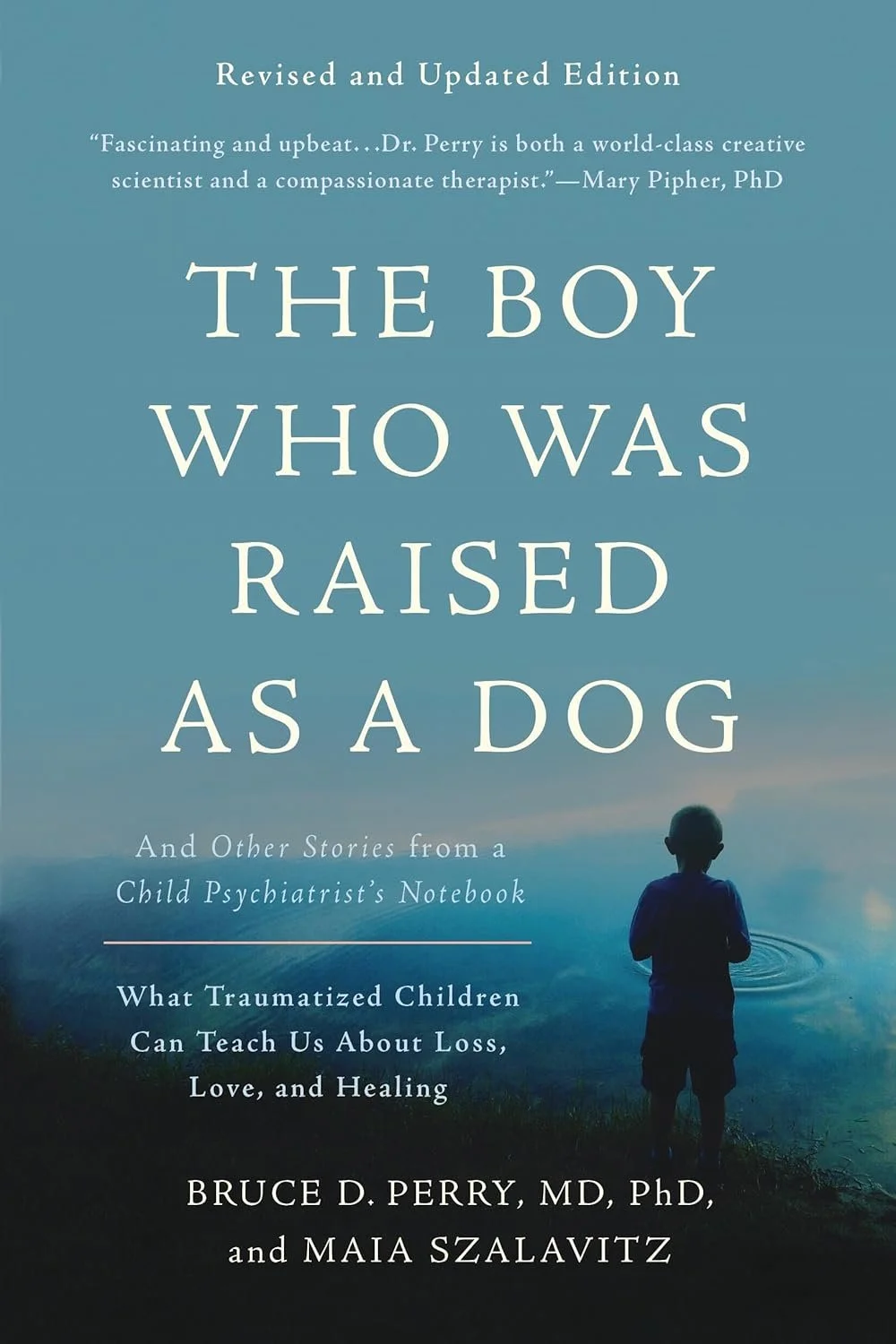 Book cover titled "The Boy Who Was Raised as a Dog" with a subtitle about trauma and healing. The cover features a silhouette of a child standing by water with a calm, bluish landscape in the background.