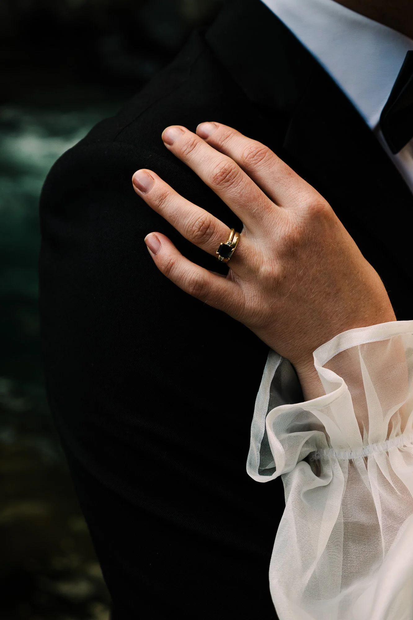Close-up of an engagement ring and wedding attire during a styled elopement at Tawhai Falls in New Zealand, photographed by Kevin M Films.