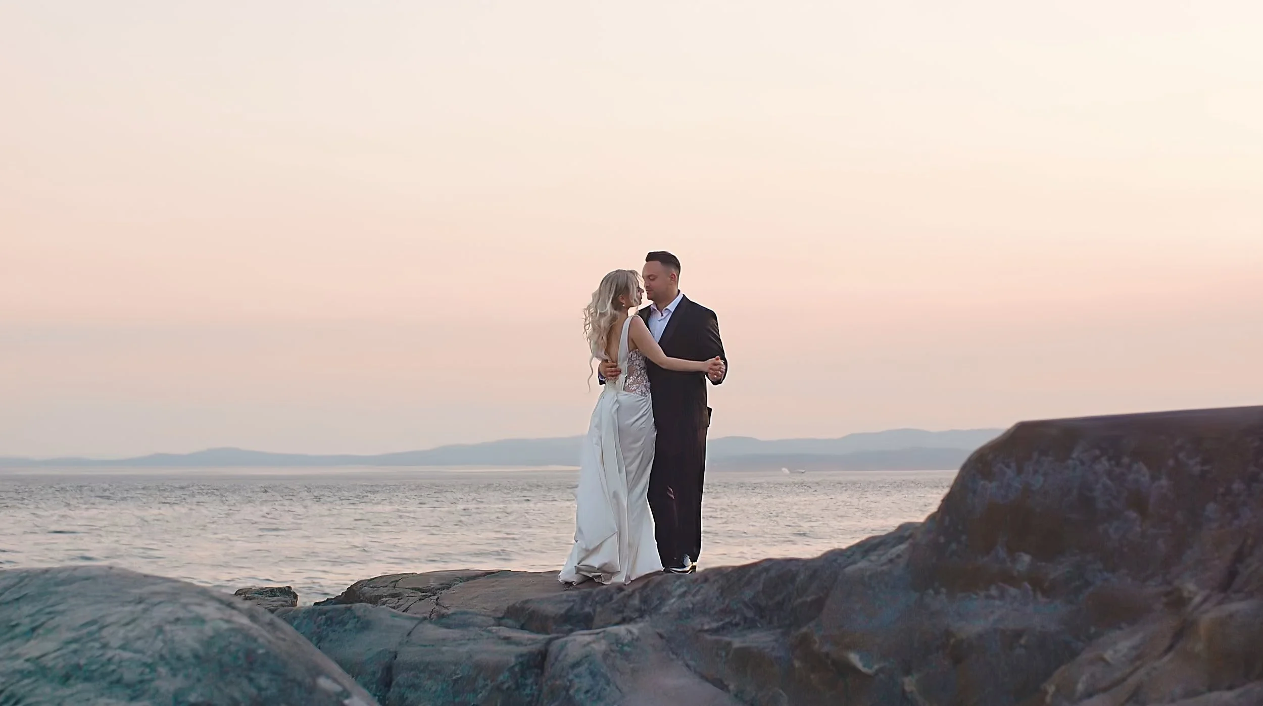 Bride and groom dancing on a ocean cliff in Victoria, B.C.