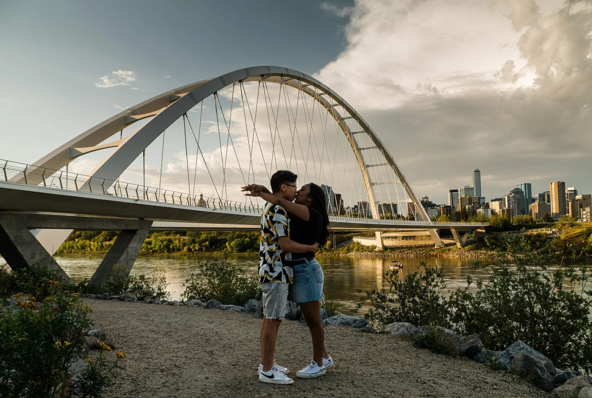 Couple kissing near Edmonton’s Walterdale Bridge during a couples photography session by Kevin M Films.