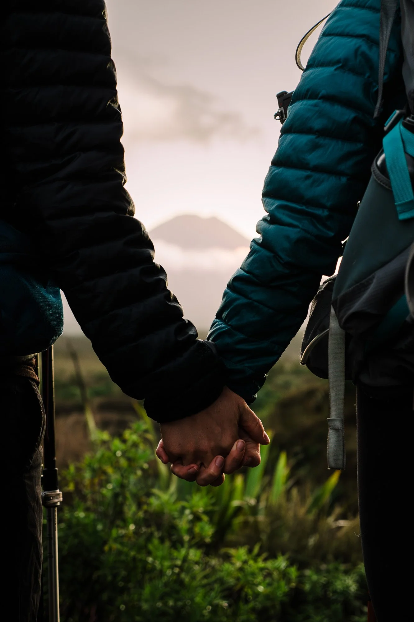 Close-up of a couple holding hands on Mounds Walk in Tongariro National Park during a New Zealand couples photography session by Kevin M Films.