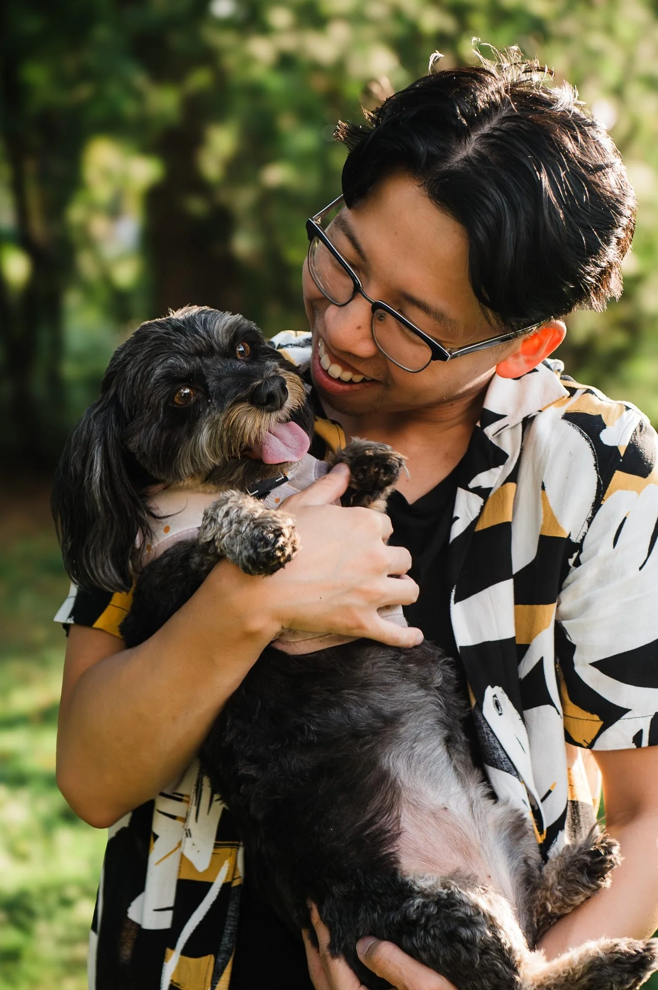 Person smiling while holding their dog during an Edmonton couples photography session by Kevin M Films.