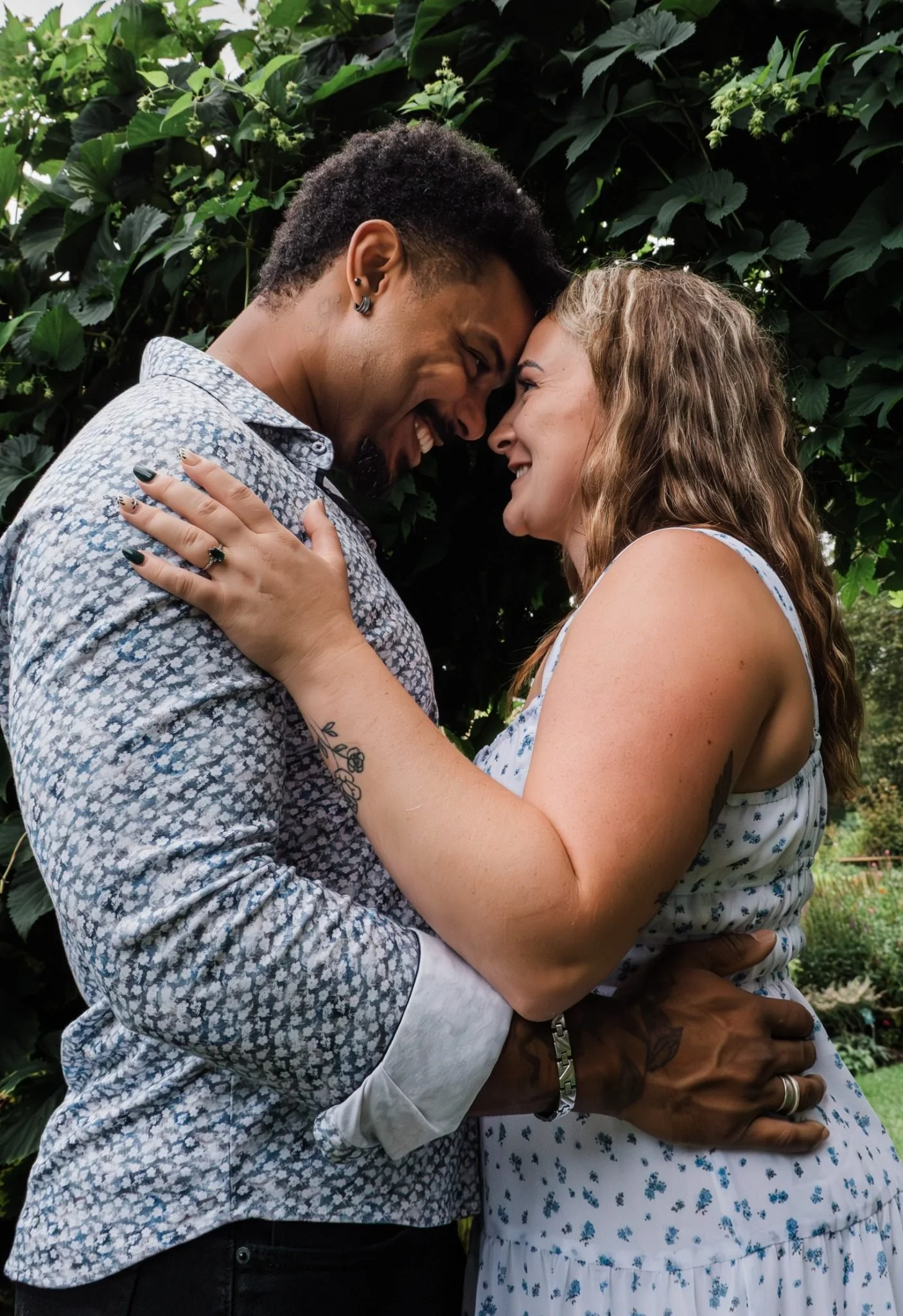 Engaged couple laughing together at St. Albert Botanic Park during an Edmonton engagement photography session by Kevin M Films.