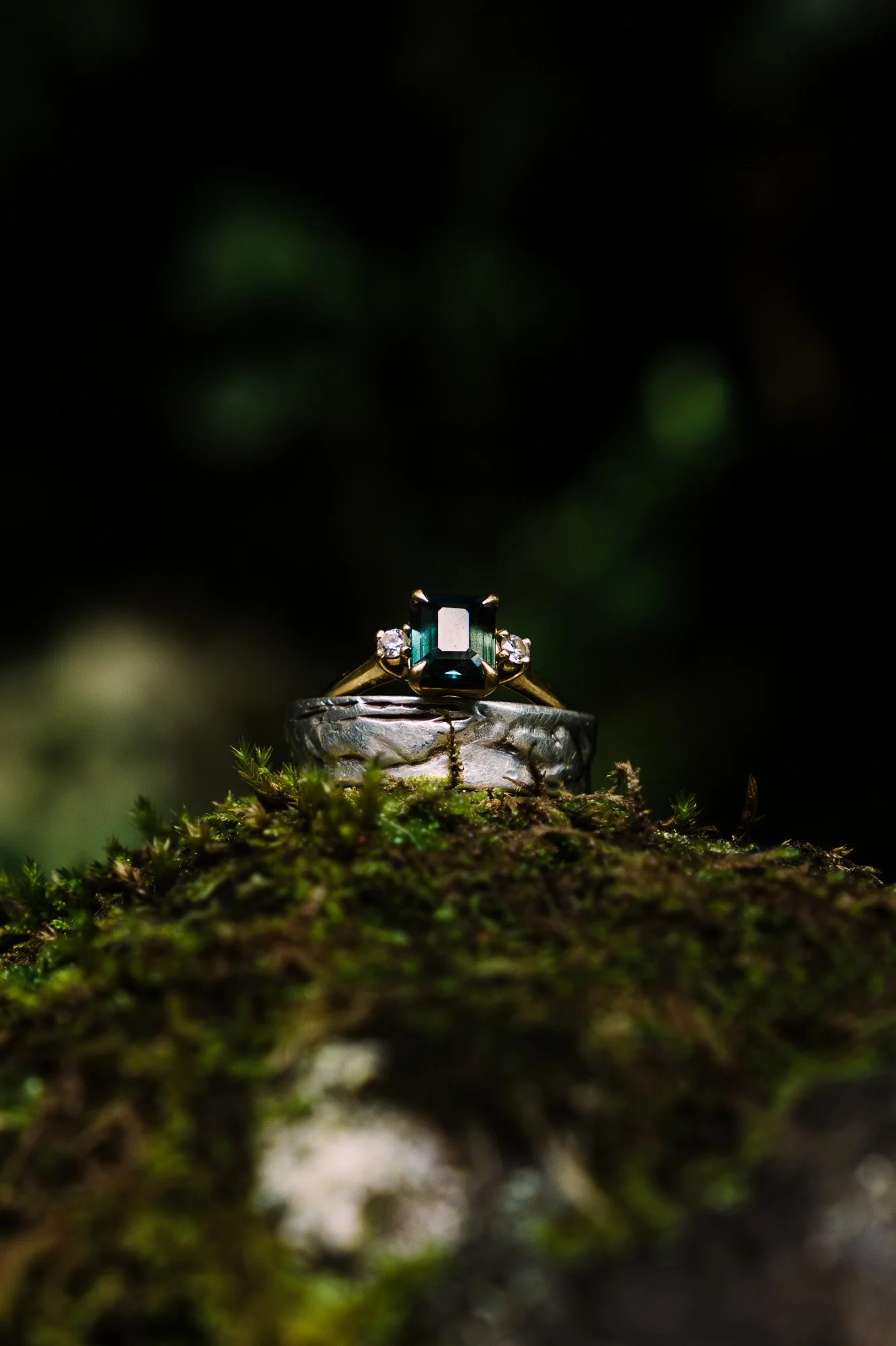 Close-up of wedding rings on moss during a New Zealand styled elopement photography session by Kevin M Films.