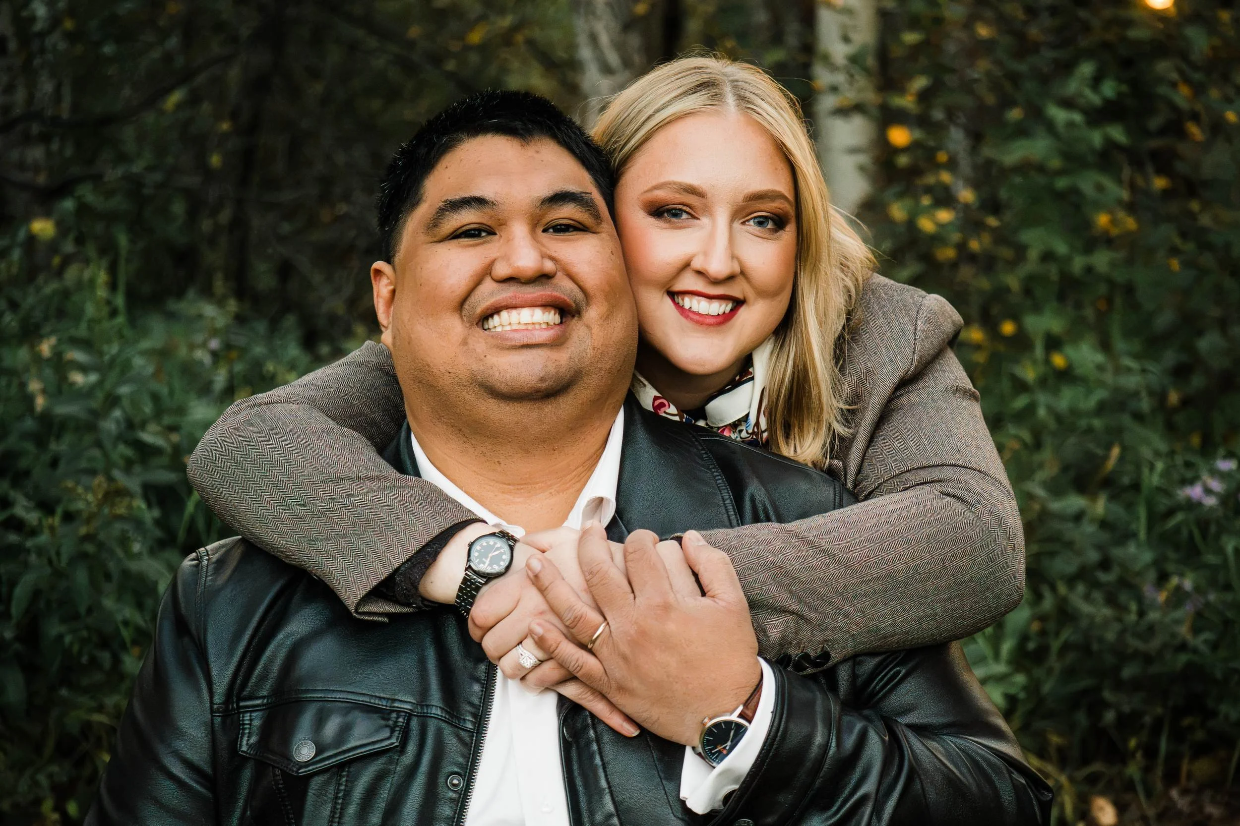 Couple smiling and embracing among the trees at Sparrow Lane in the fall.