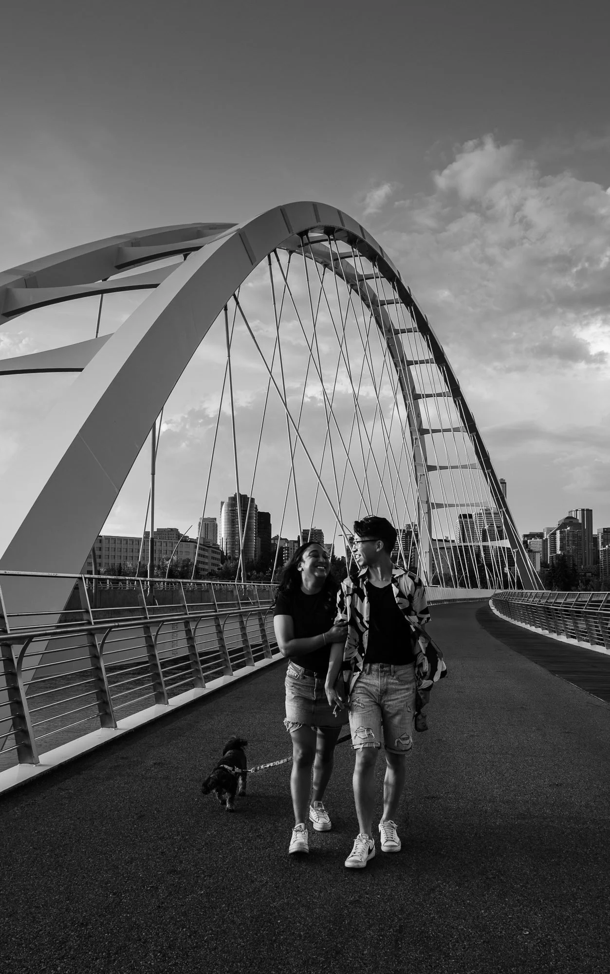Couple walking with their dog on Edmonton’s Walterdale Bridge during a couples photography session by Kevin M Films.