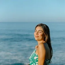 Oahu maternity Photographer review from woman smiling against ocean backdrop