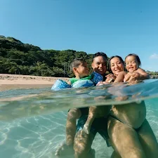 local hawaiian maternity photographer review from local family smiling together underwater in the ocean