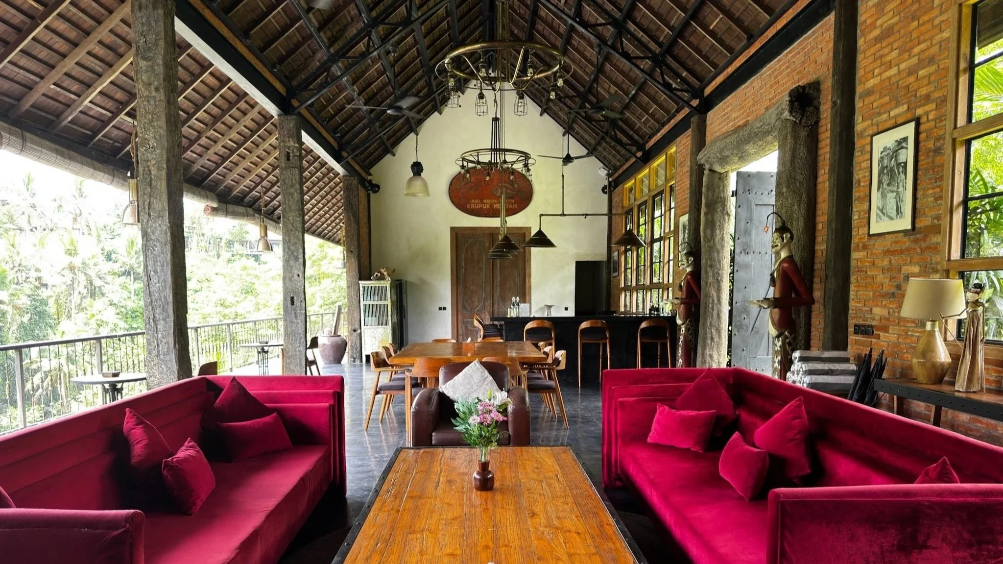 Gay men's retreat lounge area, open air Bali space with seating, dining table and kitchen.
