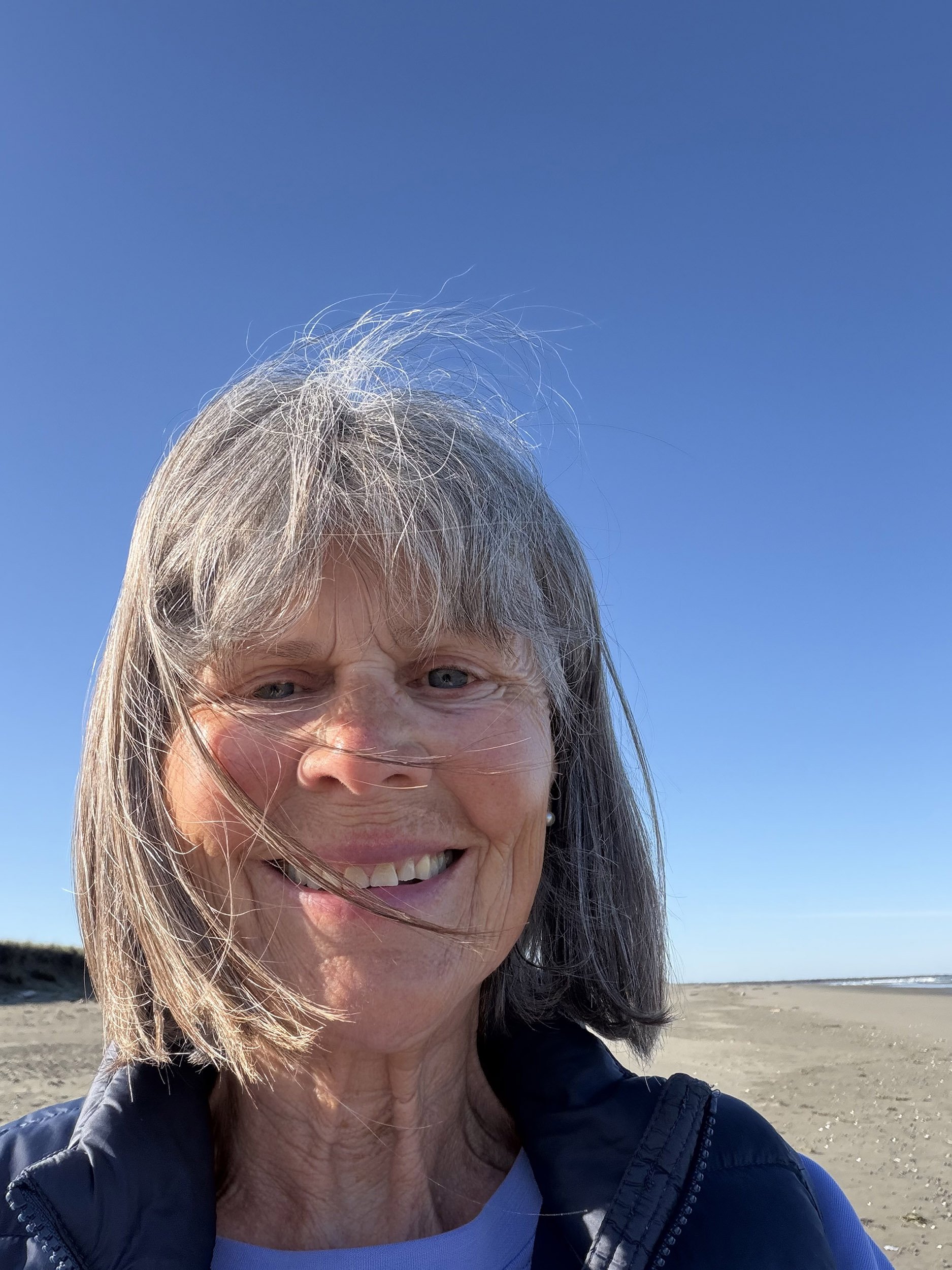 Susan Hovda at the beach on a sunny day with wind in her hair