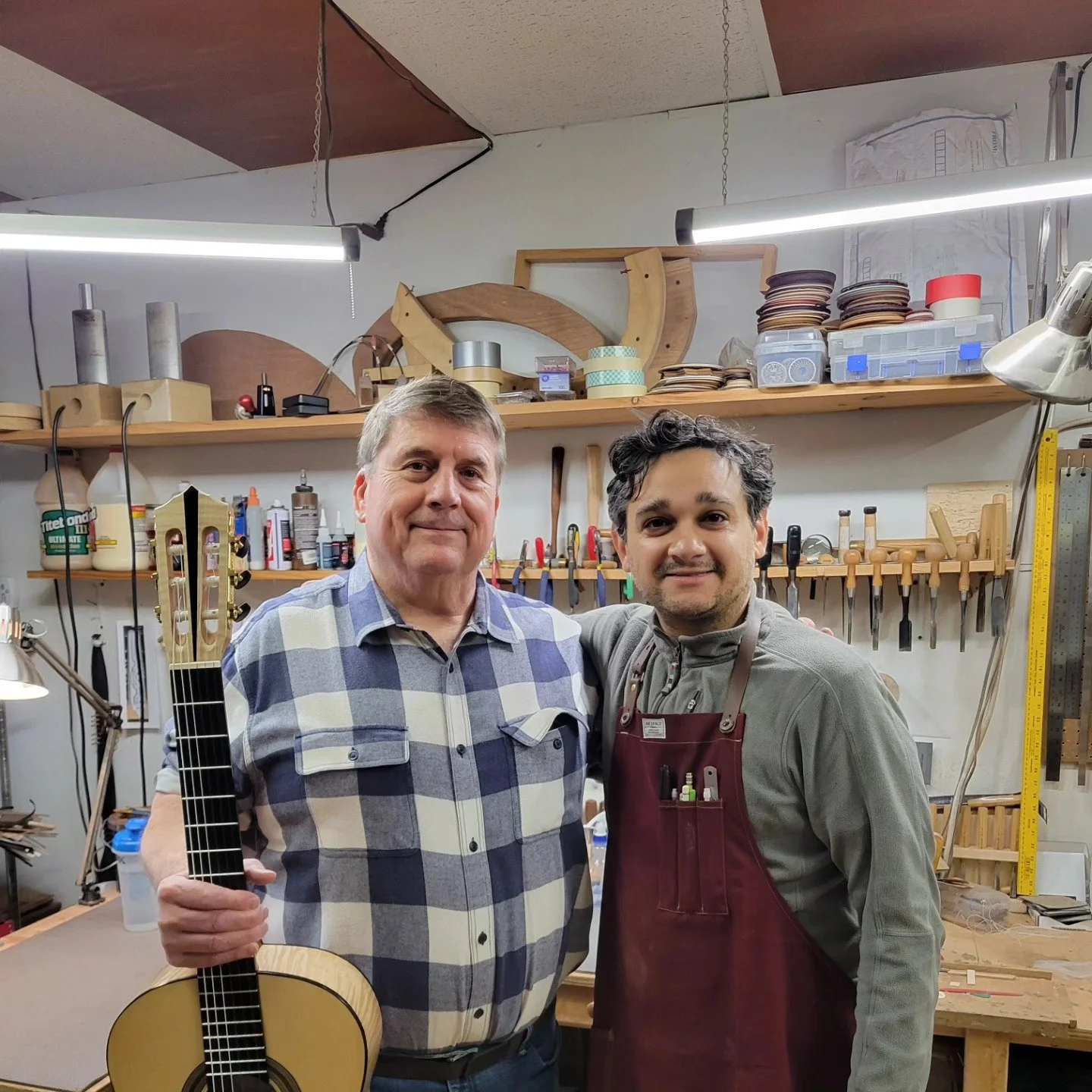 a student holds a new guitar he helped build at heritage luthier school in lexington north carolina with luthier john vergara