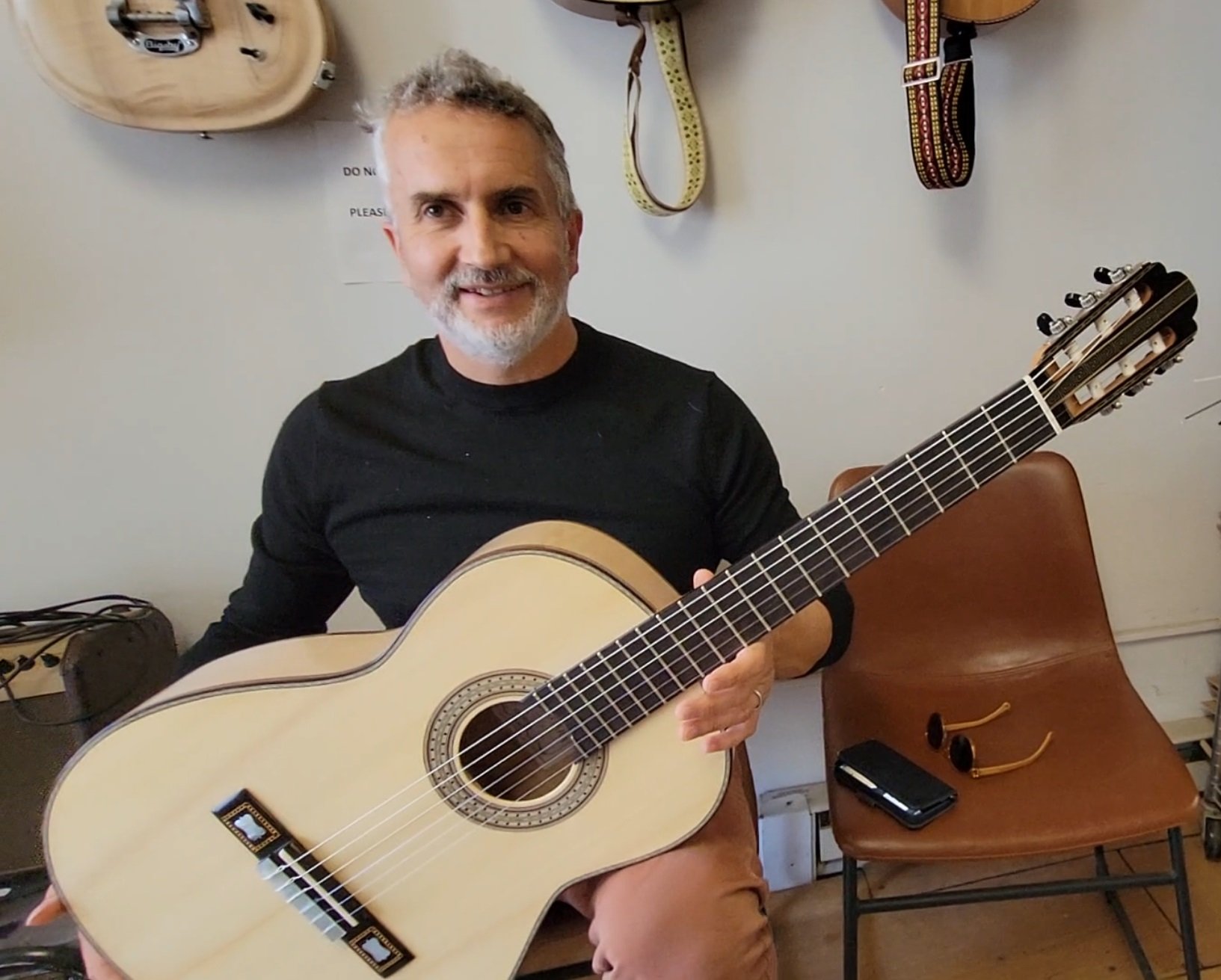 a student with a new guitar that they helped build at heritage luthier school in lexington north carolina with luthier john vergara