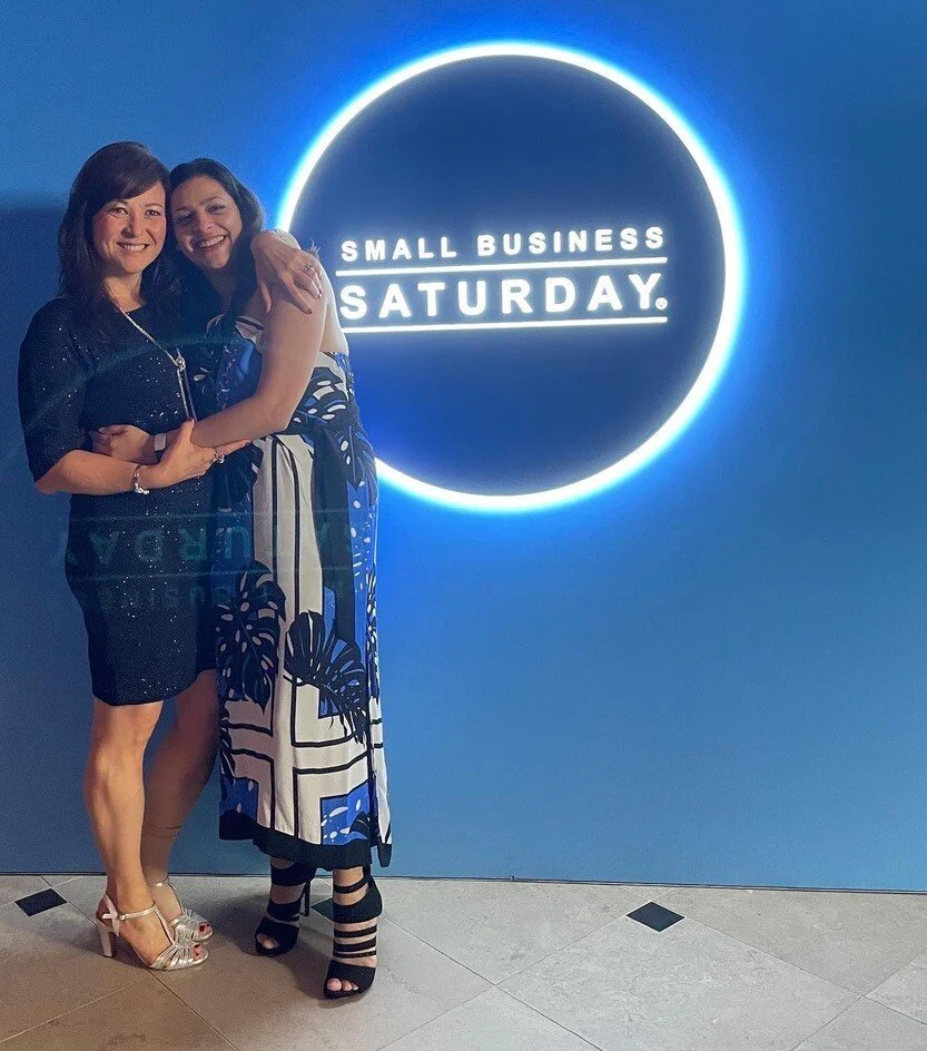 Kathy and Elle at SBS Blue Tie Ball standing in front of the SBS Logo